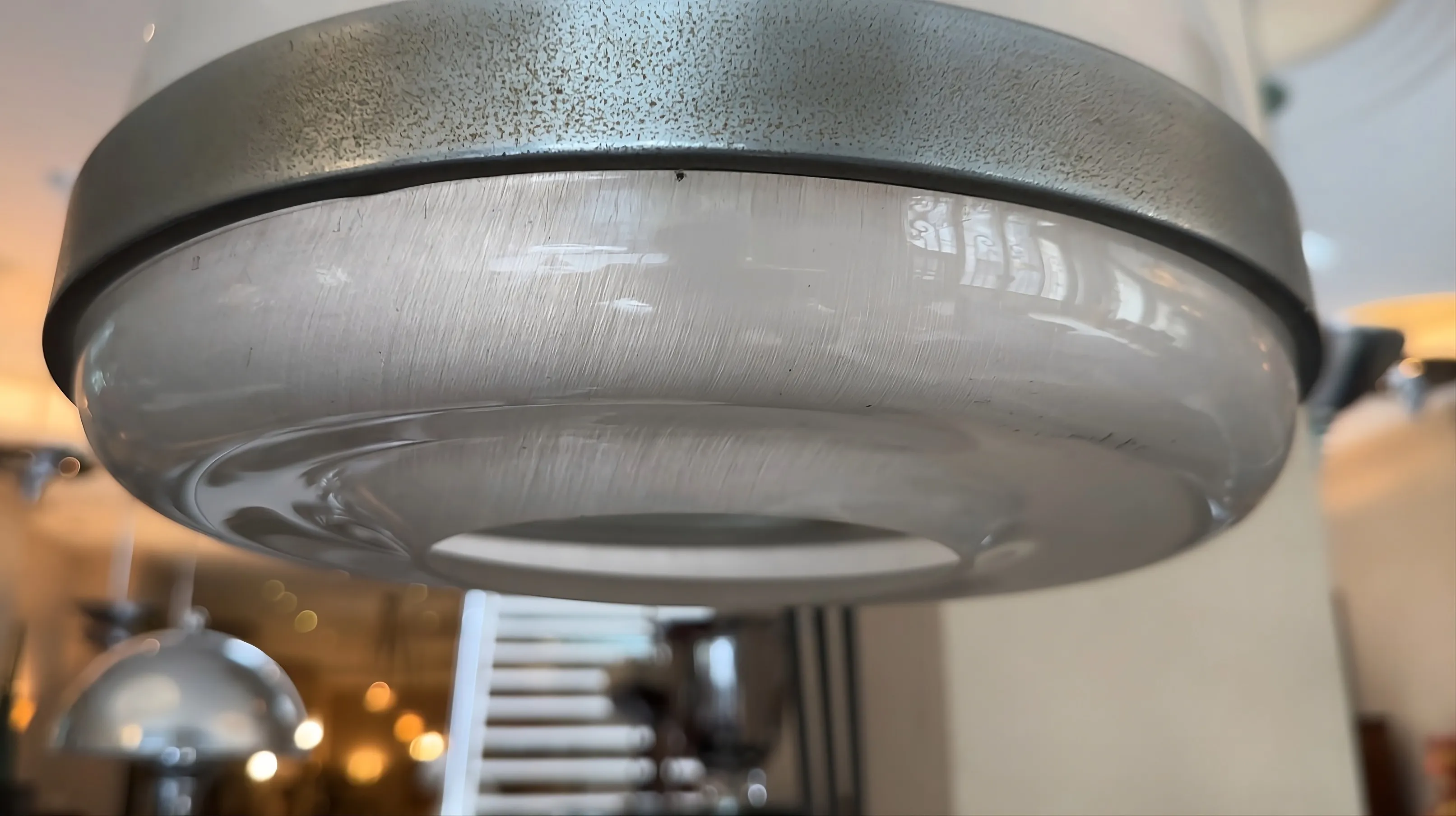 Antique floor lamp with metal base and clear shade in a well-lit setting.