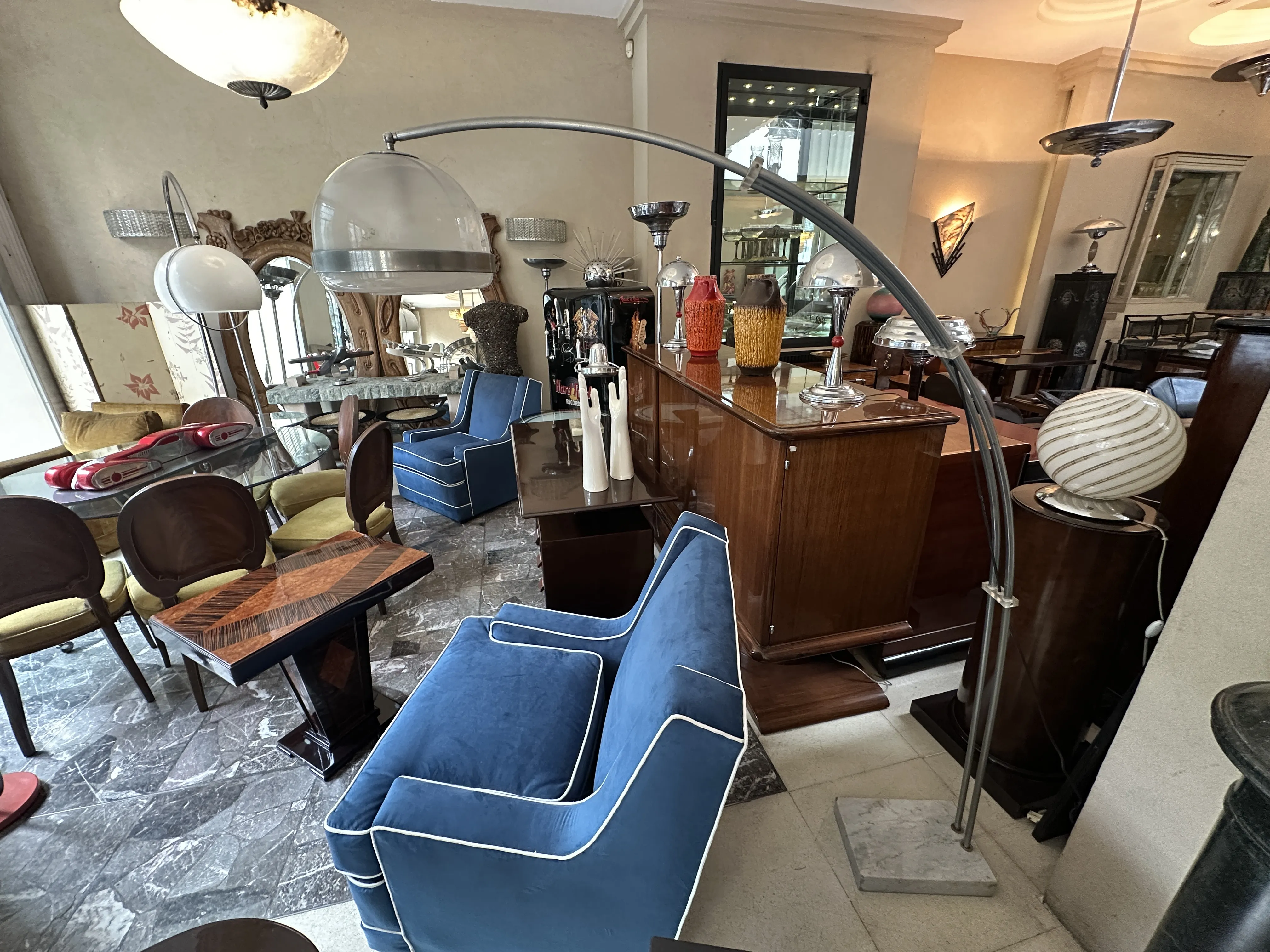 Lámpara de pie antigua con diseño curvado en una sala con muebles retro.