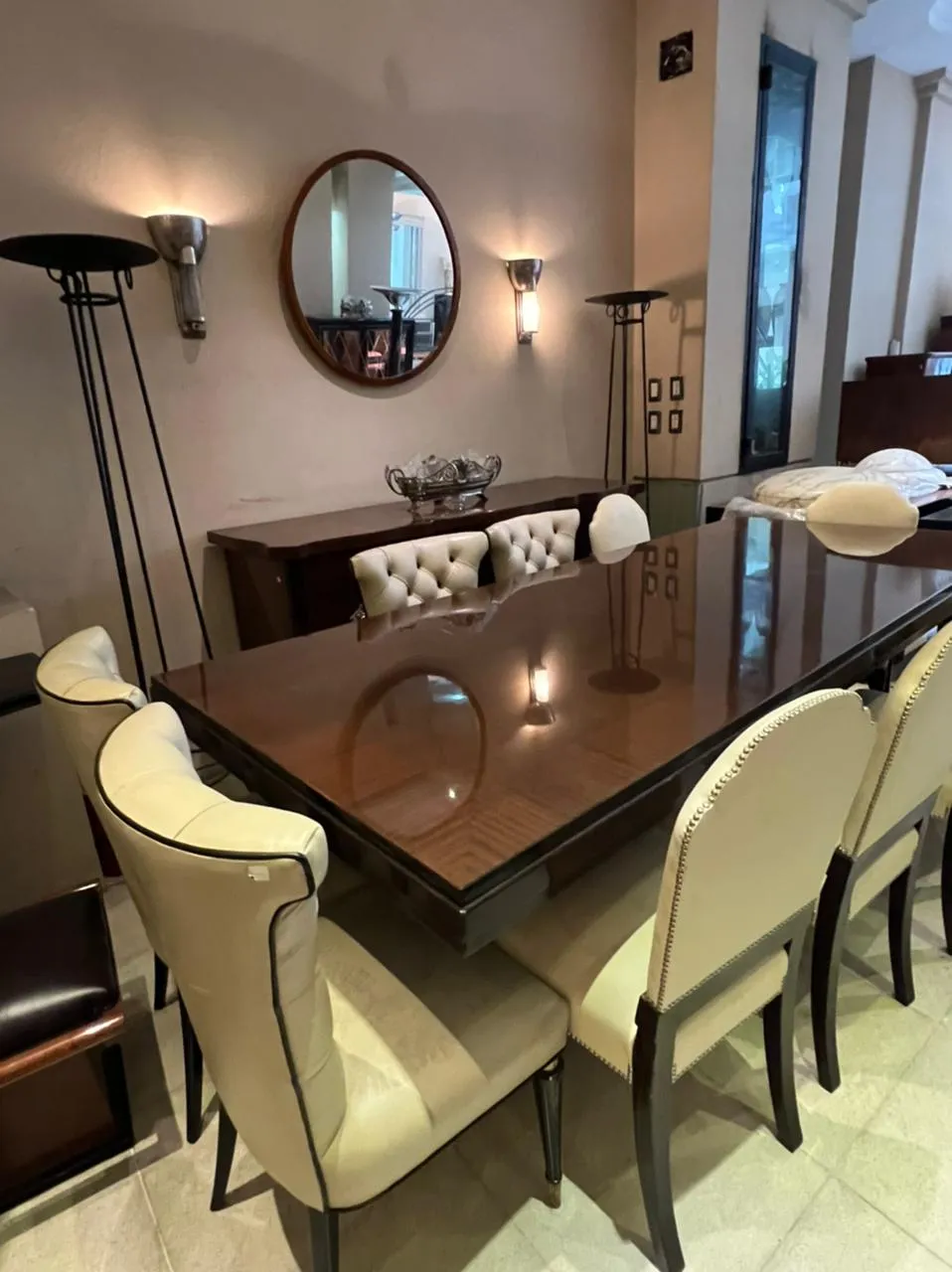 Quatro lâmpadas de piso antigas ao lado de uma elegante mesa de jantar e cadeiras