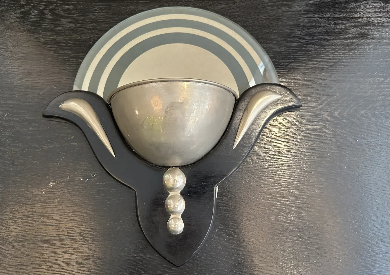 Paire d'appliques anciennes avec des formes élégantes et des couleurs argentées sur un fond noir.