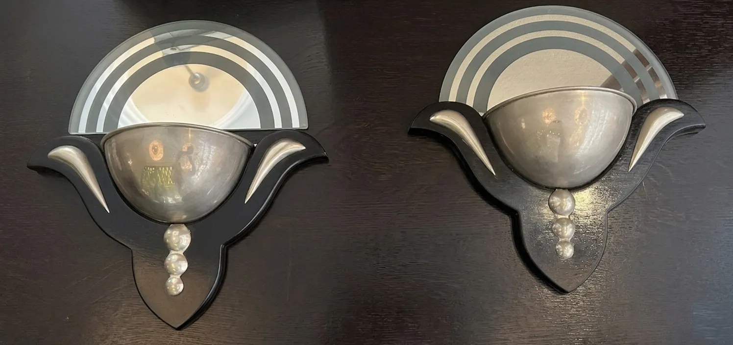 Par de apliques antiguos de estilo Art Deco con acabado elegante, paneles decorativos y forma curvilínea.