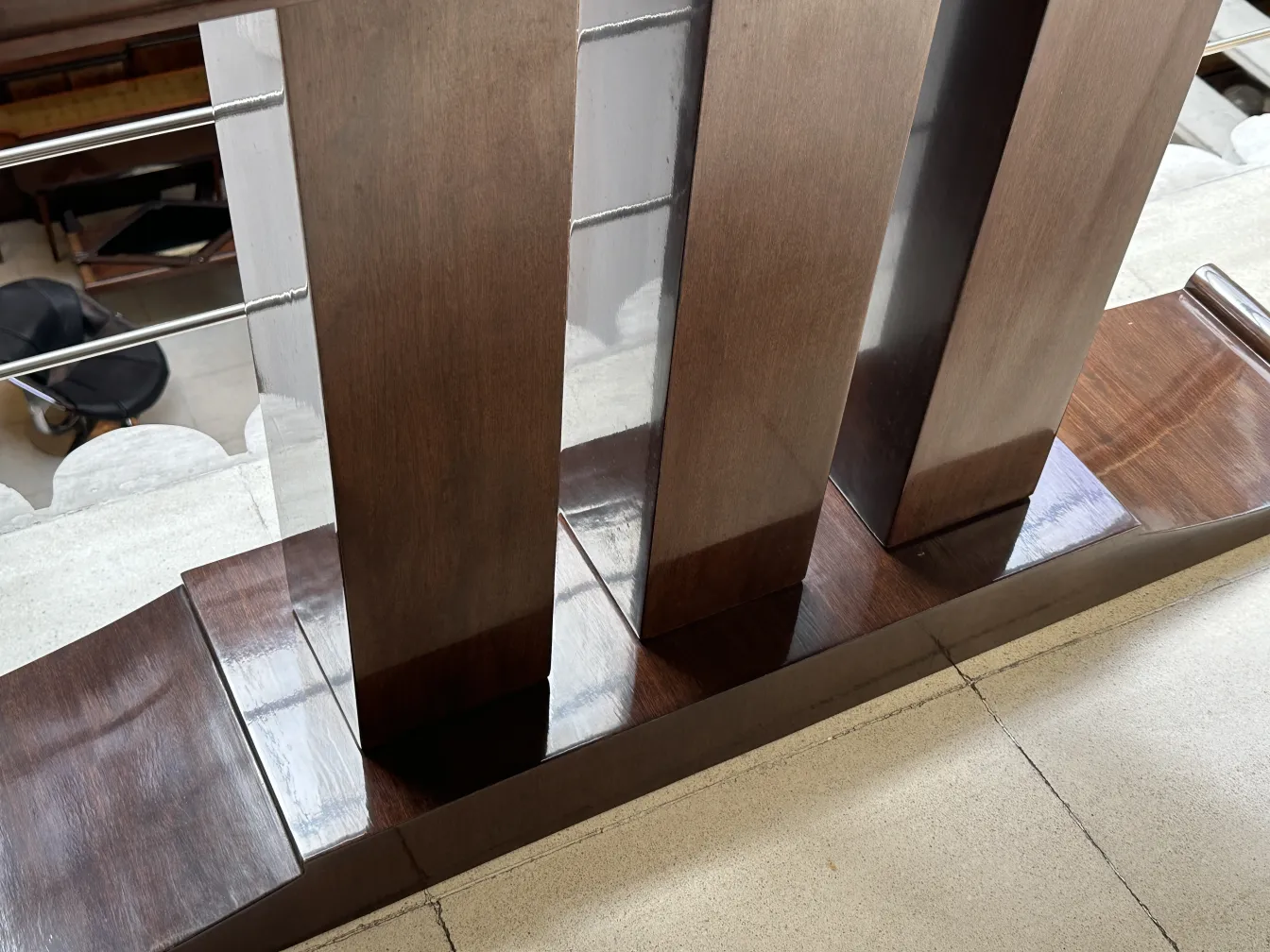 Vista dettagliata di un'antica console con design elegante, circondata da un ambiente classico.