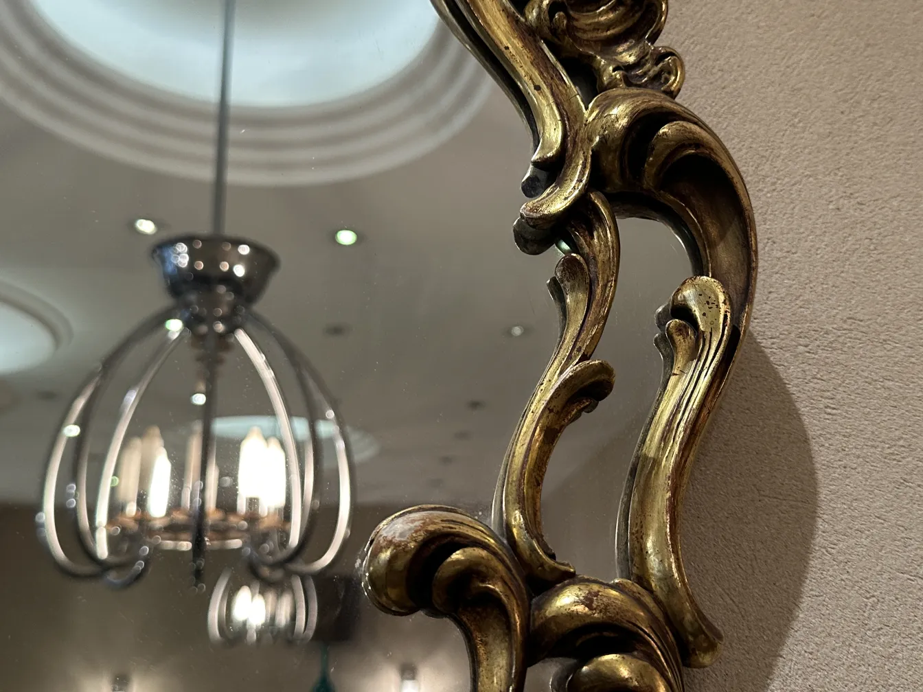 espelho antigo com moldura elaborada e luz refletida