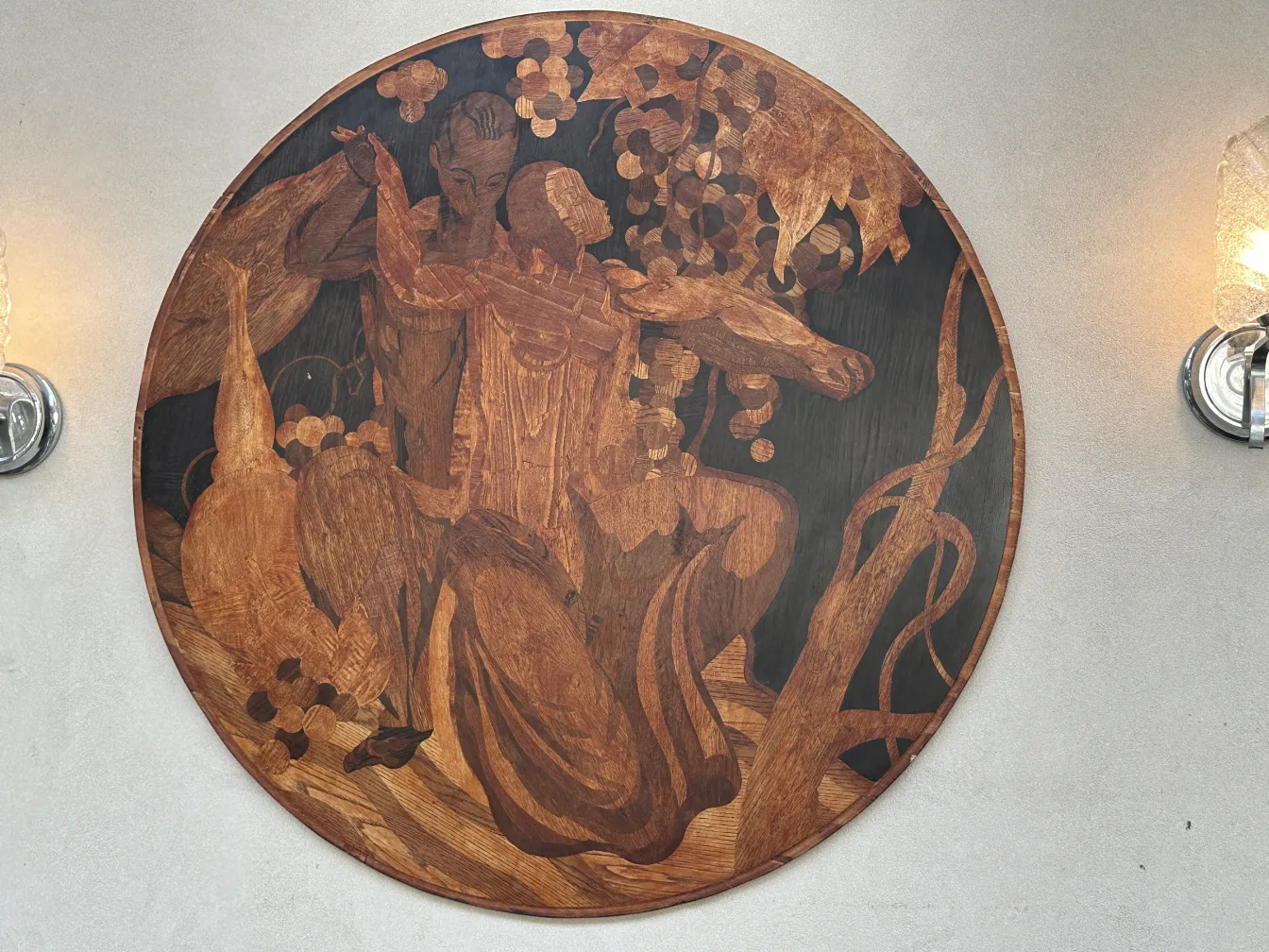 antique marquetry in brown tones with human figures against a natural background