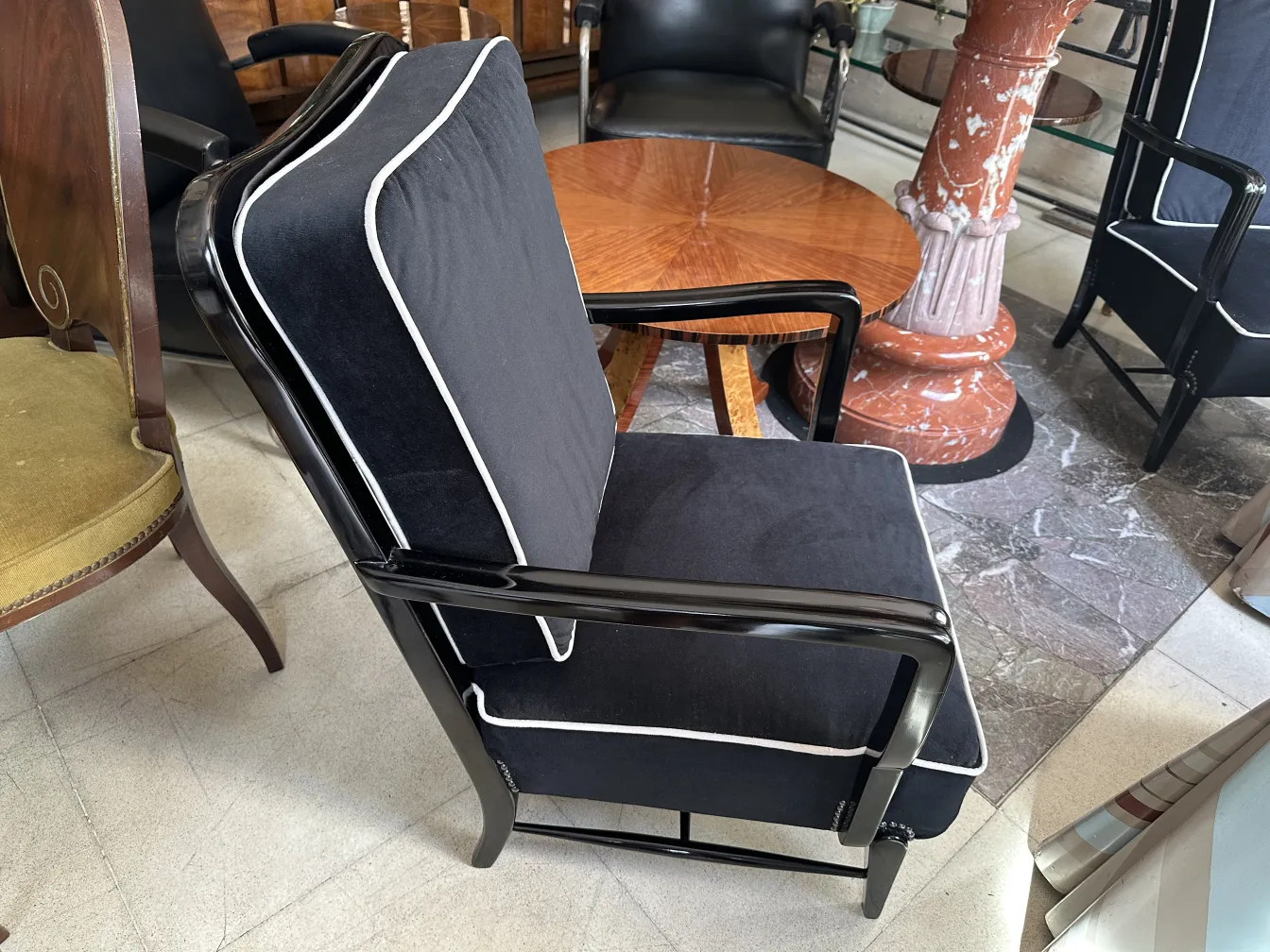 duas poltronas antigas pretas com detalhes brancos em um ambiente elegante