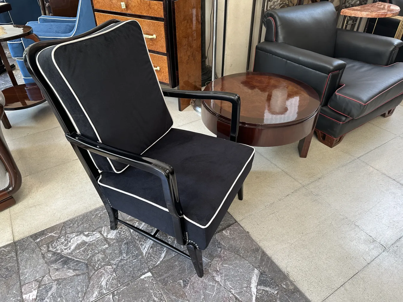 Dos sillones antiguos con almohadones oscuros y detalles claros, en un ambiente elegante.