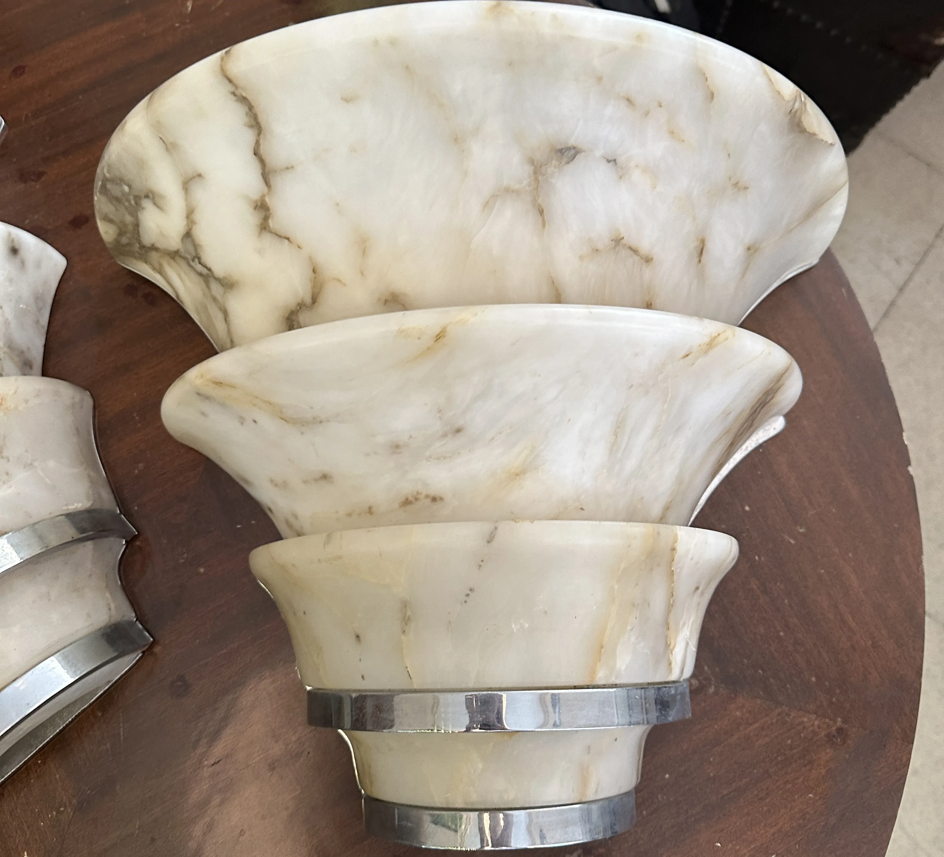 Par de luminárias de parede antigas com design curvo claro, em mesa de madeira