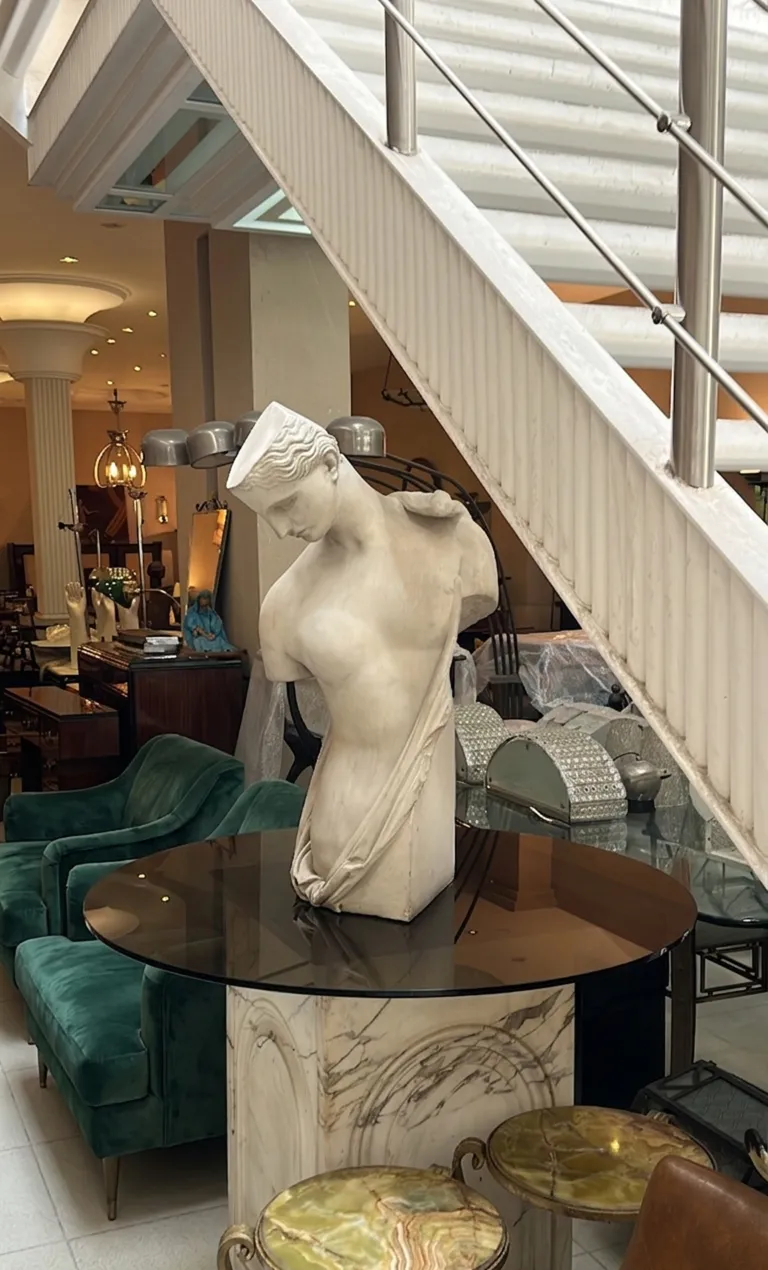 scultura antica di figura femminile con dettagli morbidi in un contesto elegante