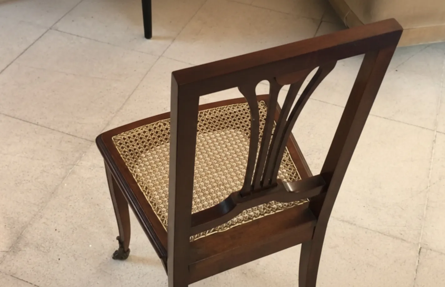 Side view of 2 antique chairs with elegant backrest in a cozy environment.