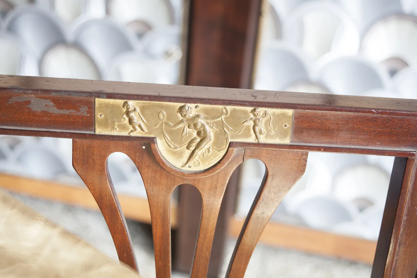 Detail of antique chairs with golden decorative edges in an elegant setting.