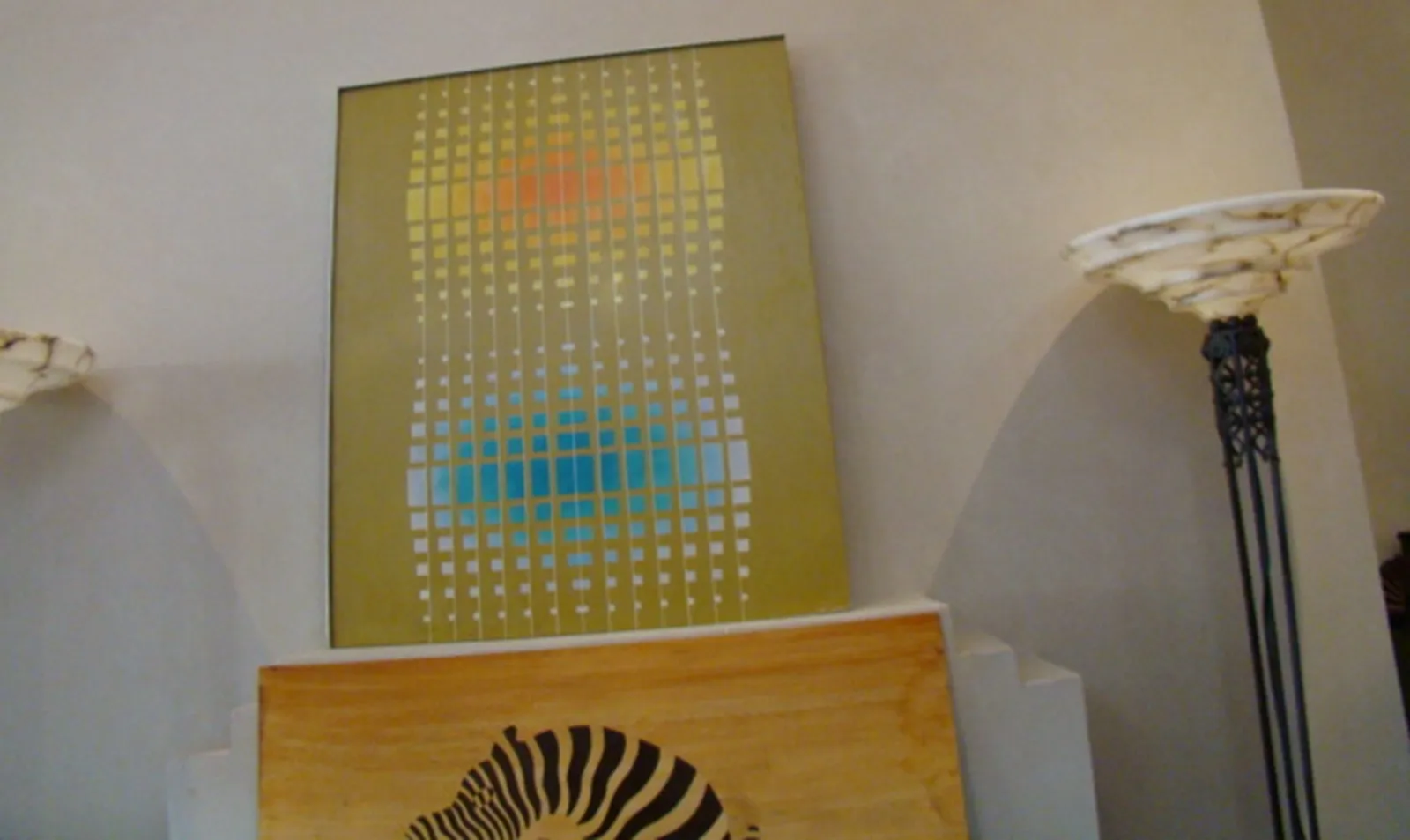 Pintura antigua con formas geométricas y colores cálidos, fondo amarillo.