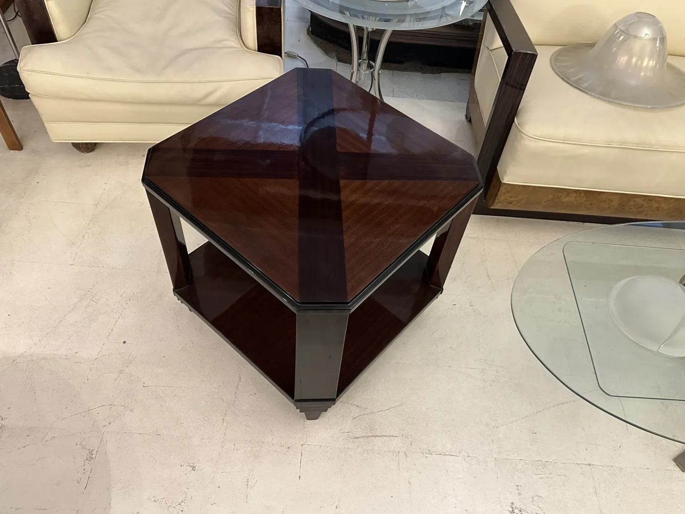 Mesa ratona antigua Art Deco de forma hexagonal, con un acabado brillante, exhibida en una habitación con muebles contemporáneos.