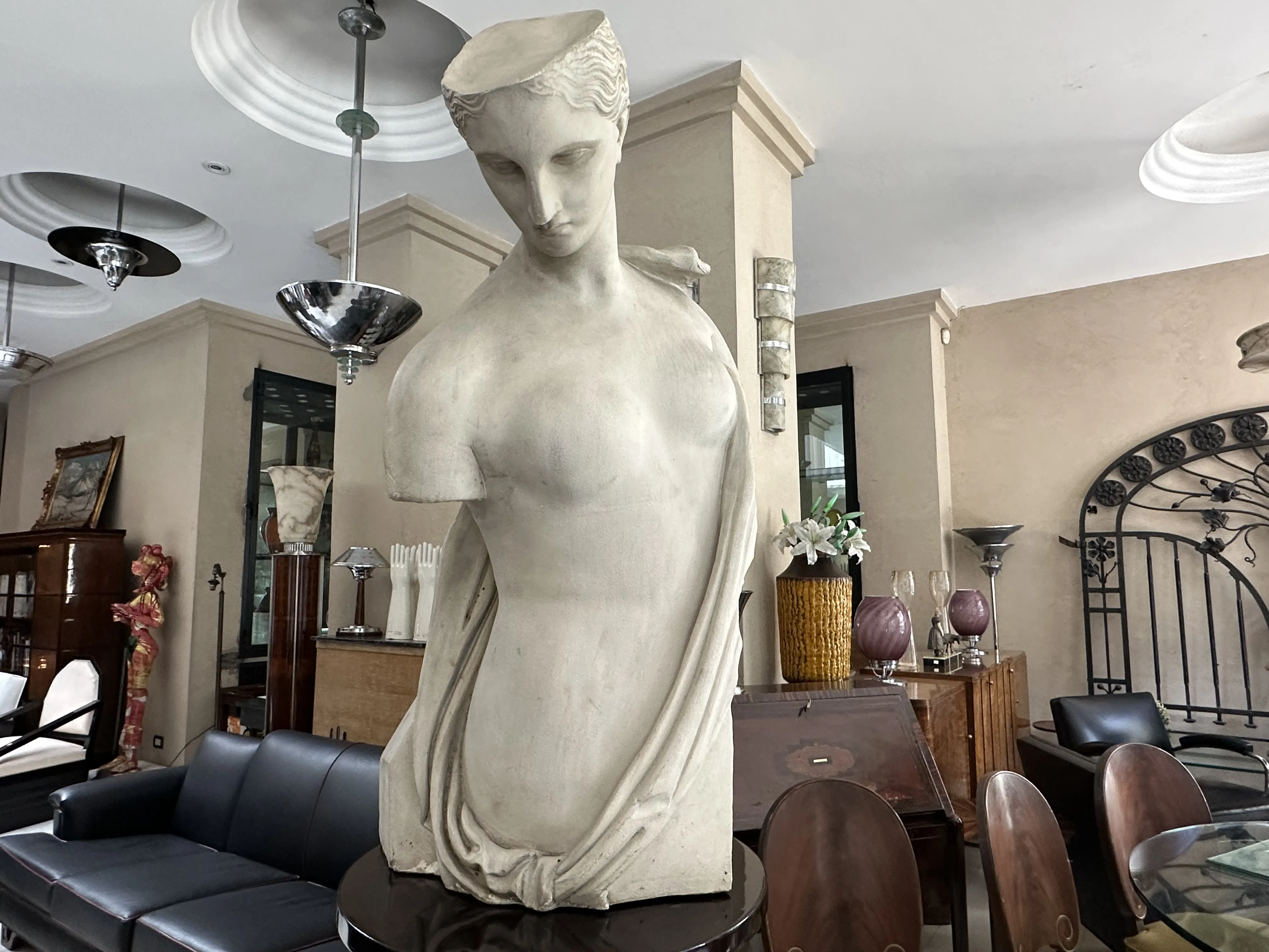Escultura antigua de Pietro Barzanti, figura esbelta y elegante, en un entorno moderno con decoración