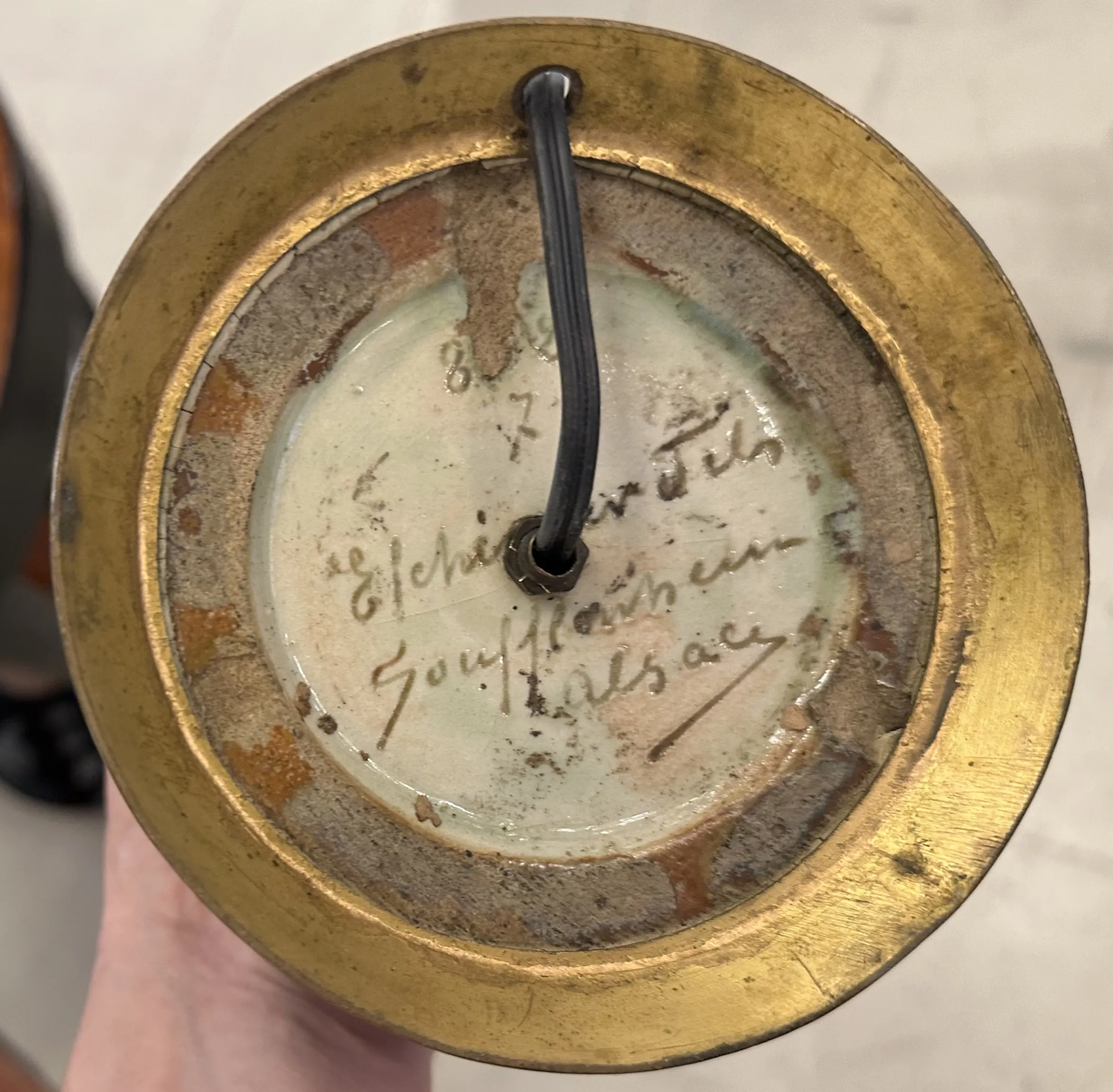 Vista de la base de una lámpara de mesa antigua con firma.