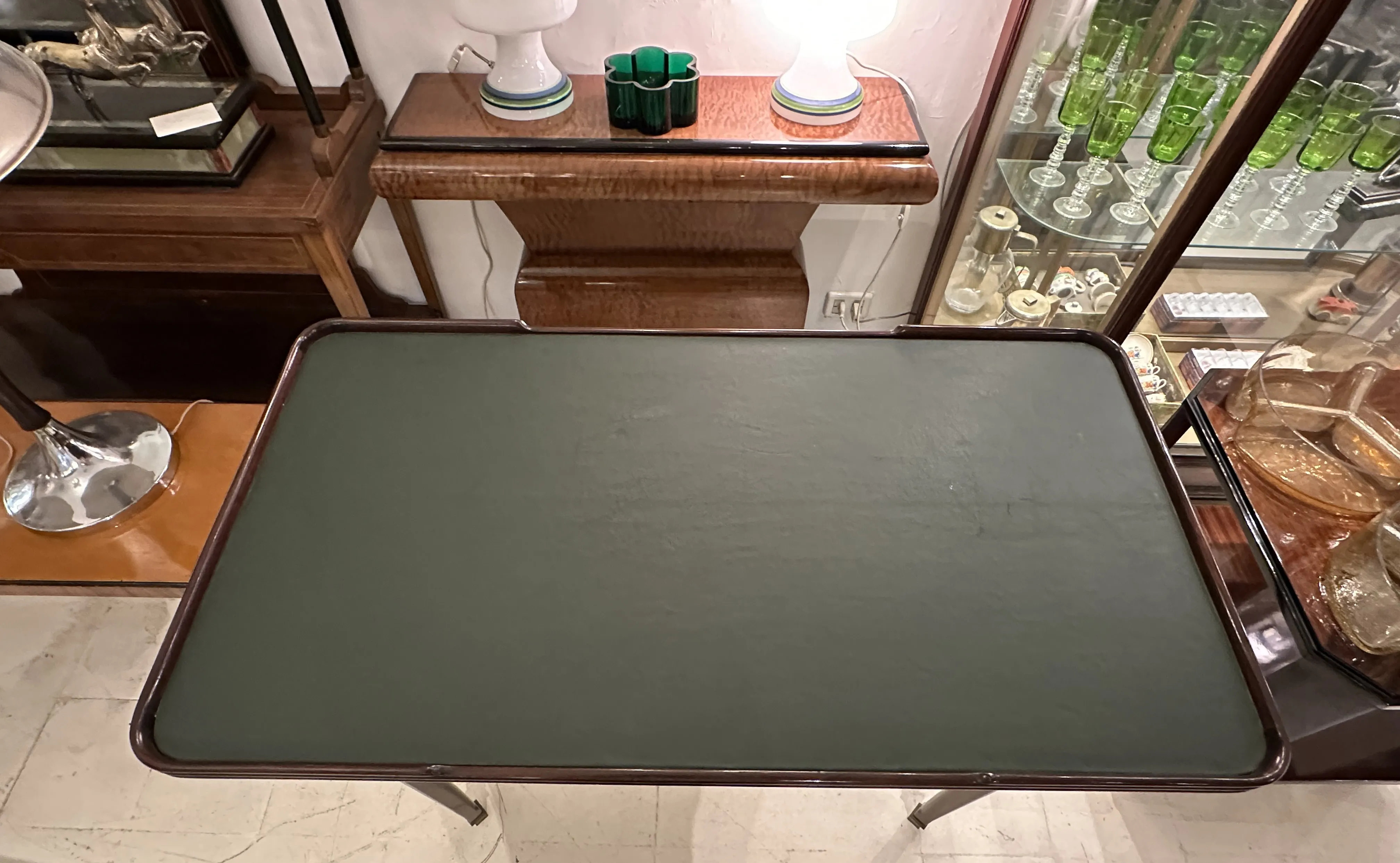 escritorio antiguo con superficie verde y detalles decorativos en el fondo