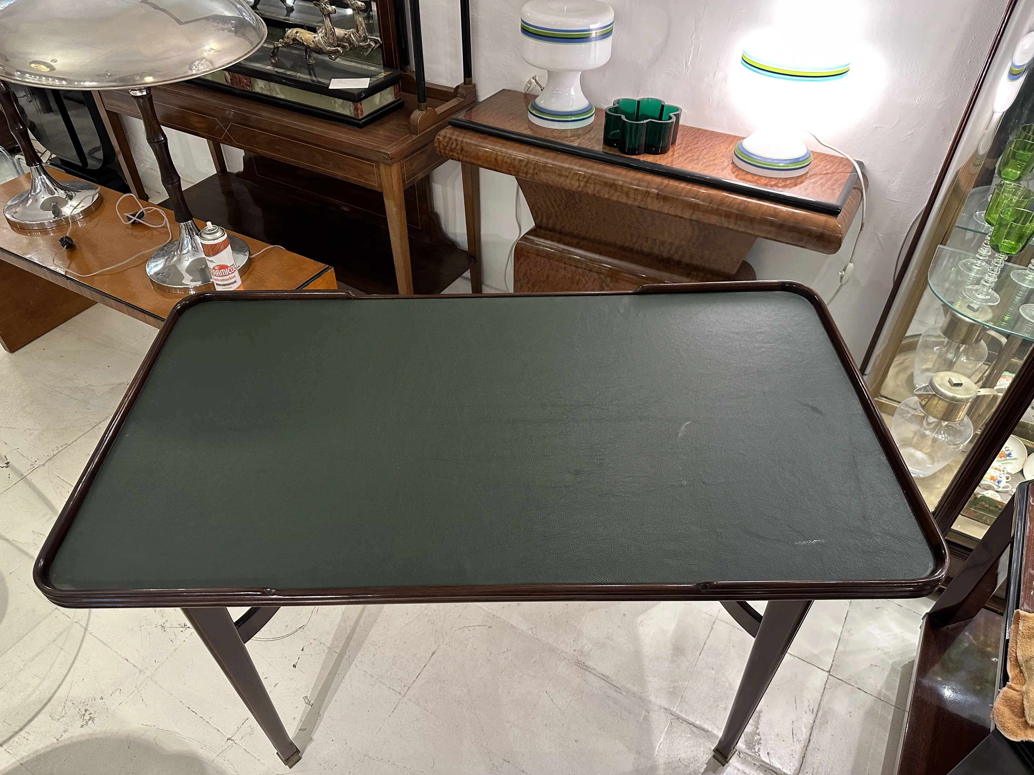 mesa de comedor antigua de color verde para cuatro personas en un entorno elegante