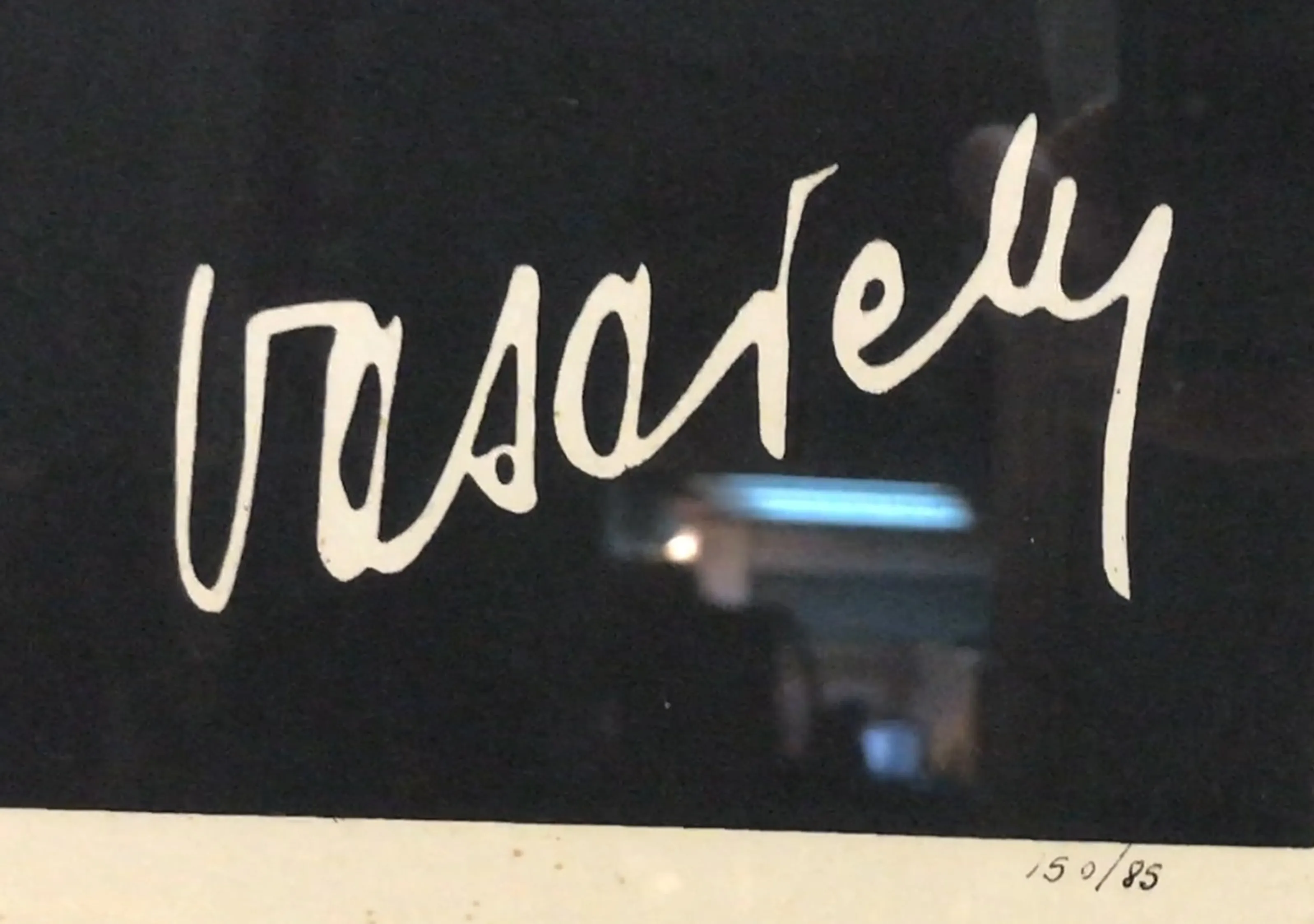 Firma de Vasarely sobre fondo negro, detalle de lámina antigua.