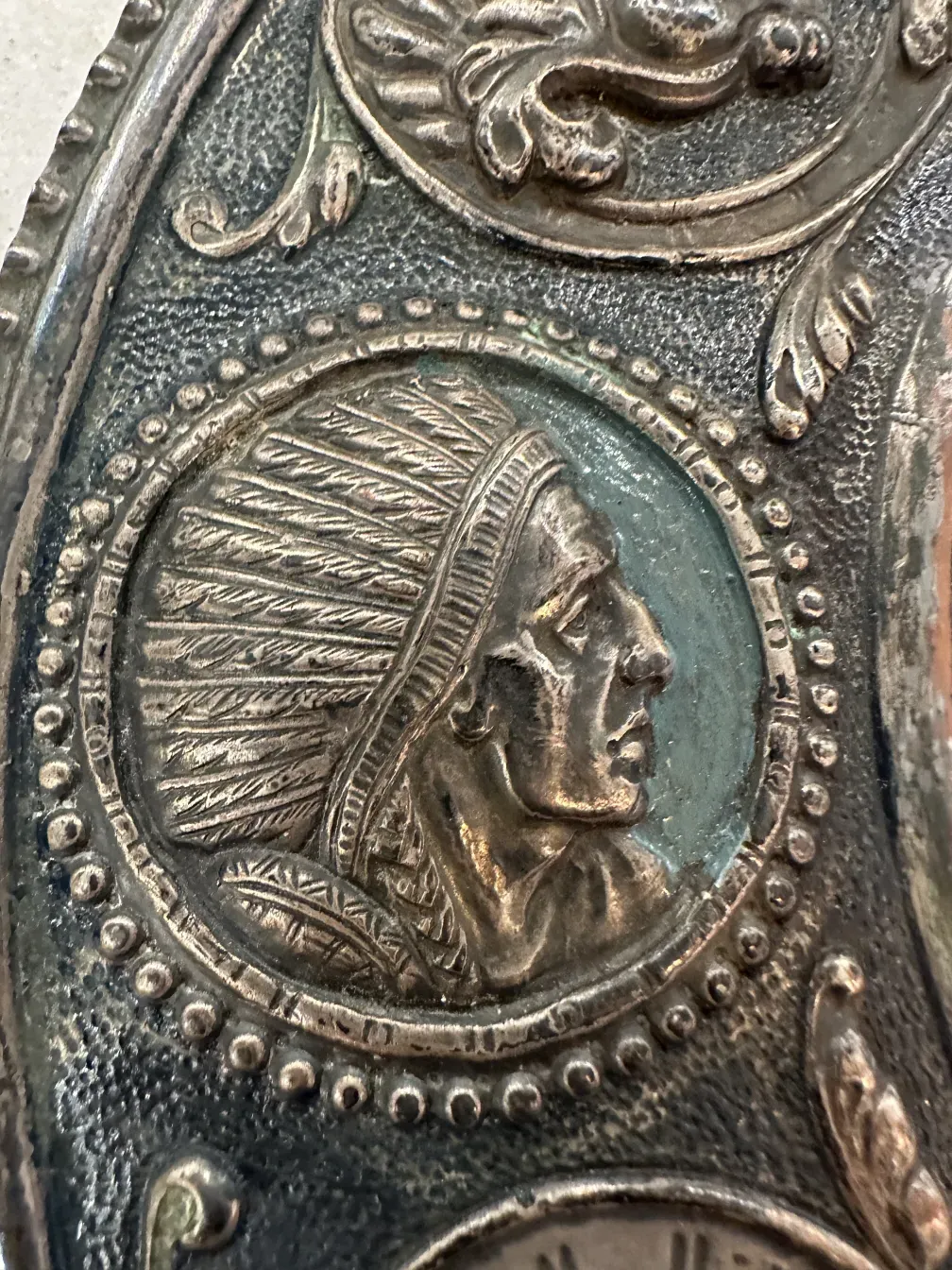 detail of antique wall plate featuring Native American figure