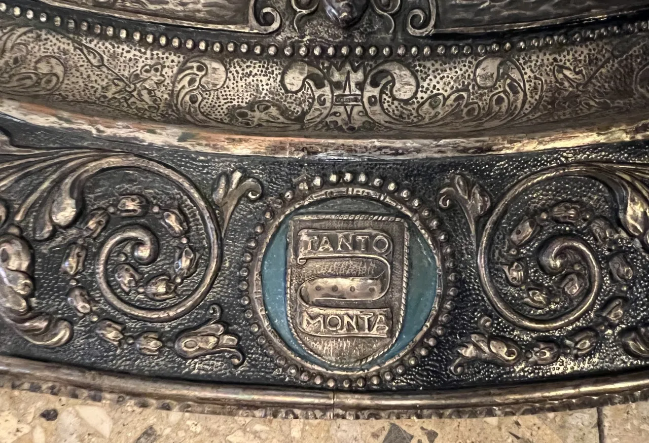 placca a muro antica con design intricato in metallo, appesa al muro