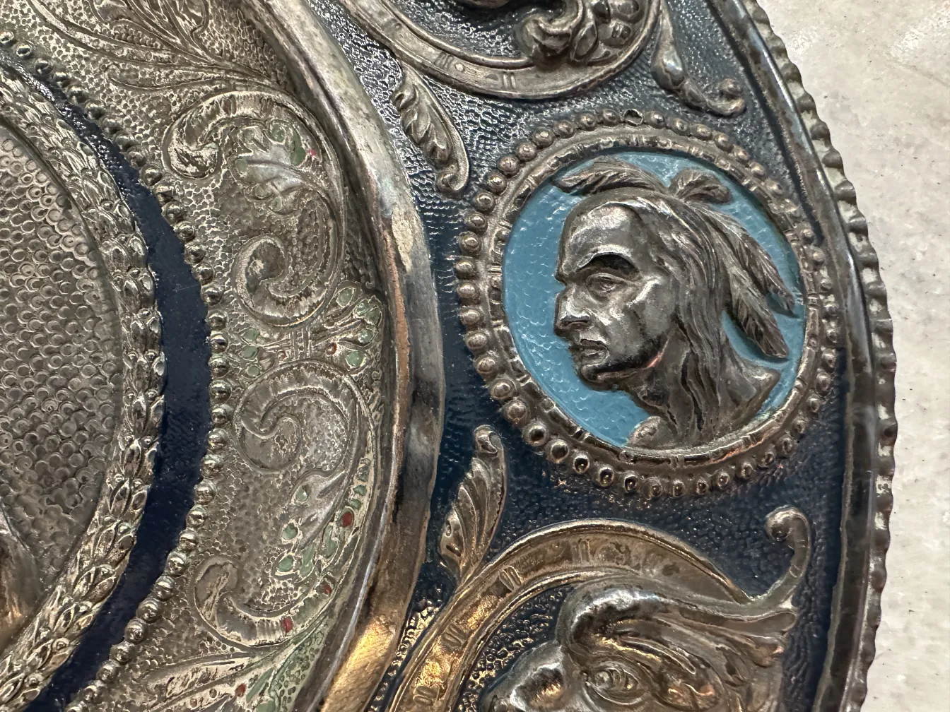 Placa de pared antigua que representa a Cristóbal Colón con detalles ornamentales.