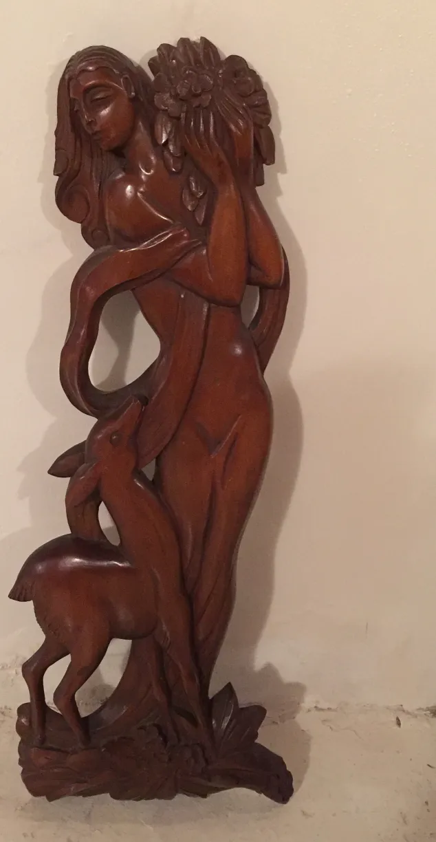 Antigua placa de pared con figura humana y ciervo en fondo claro