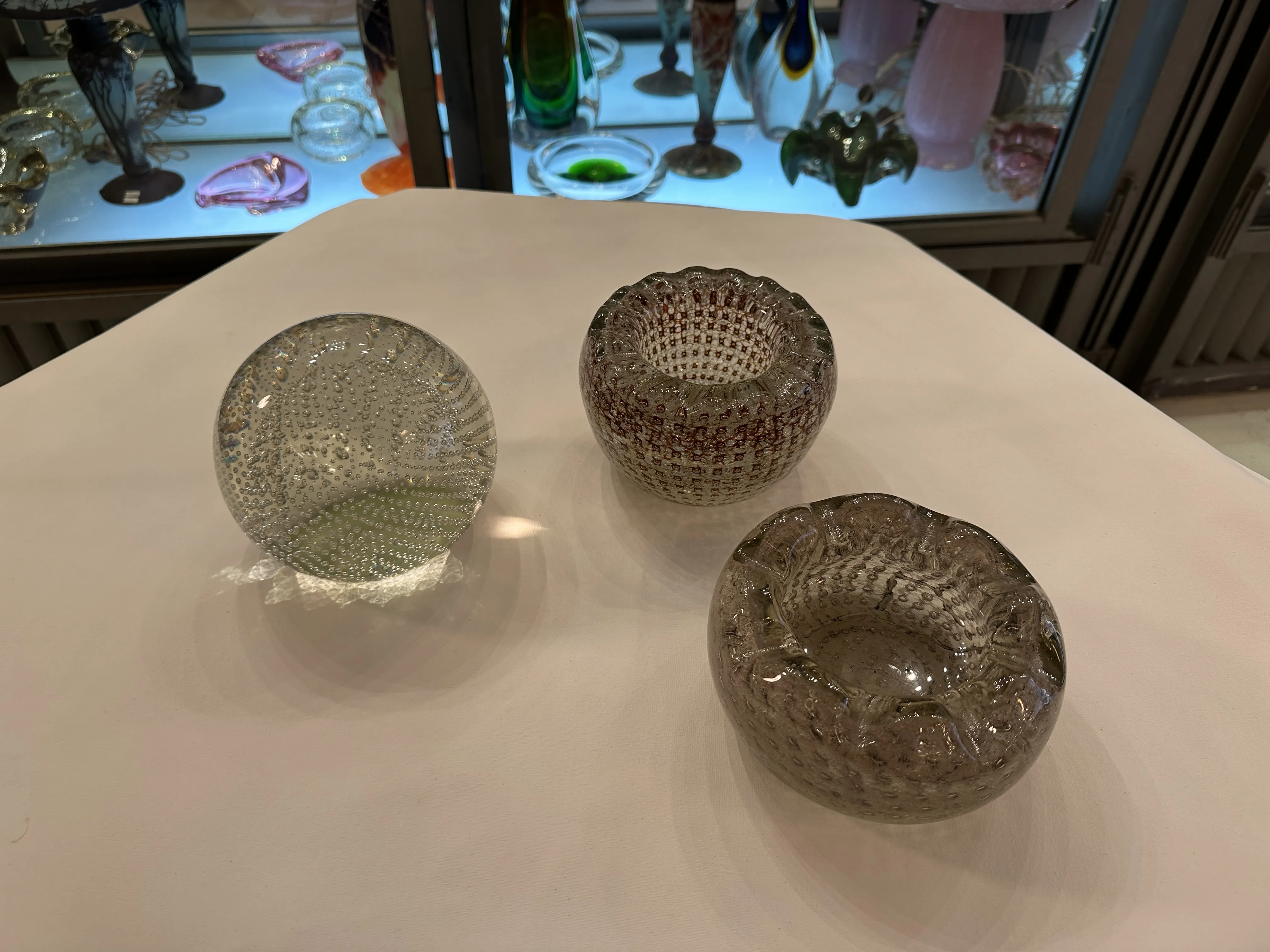 テーブル上の古いムラーノガラスの三つのピース、泡と装飾的なデザイン、他のガラス製品の背景。