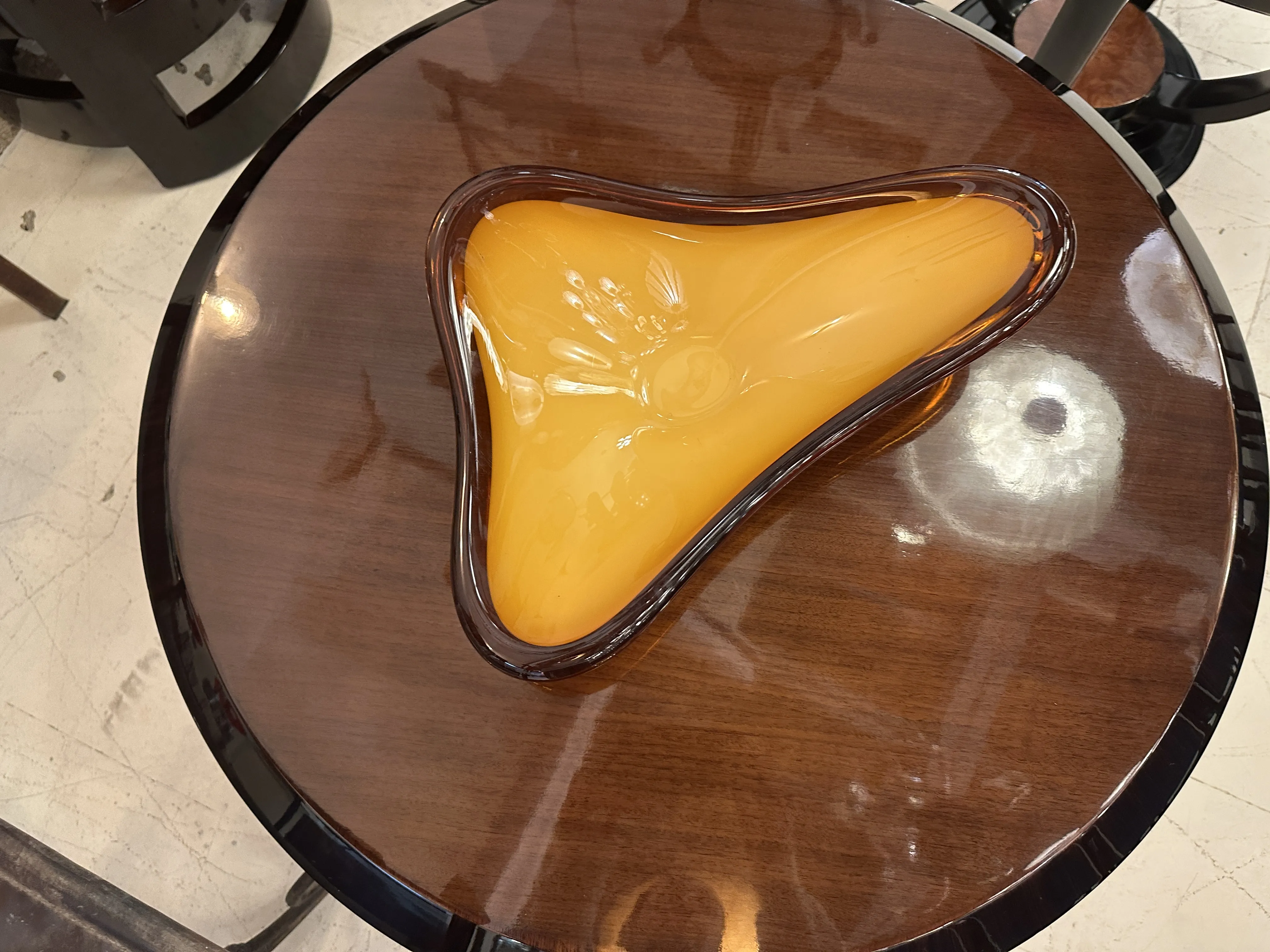 Antique Murano glass in yellow with an irregular design on a table.