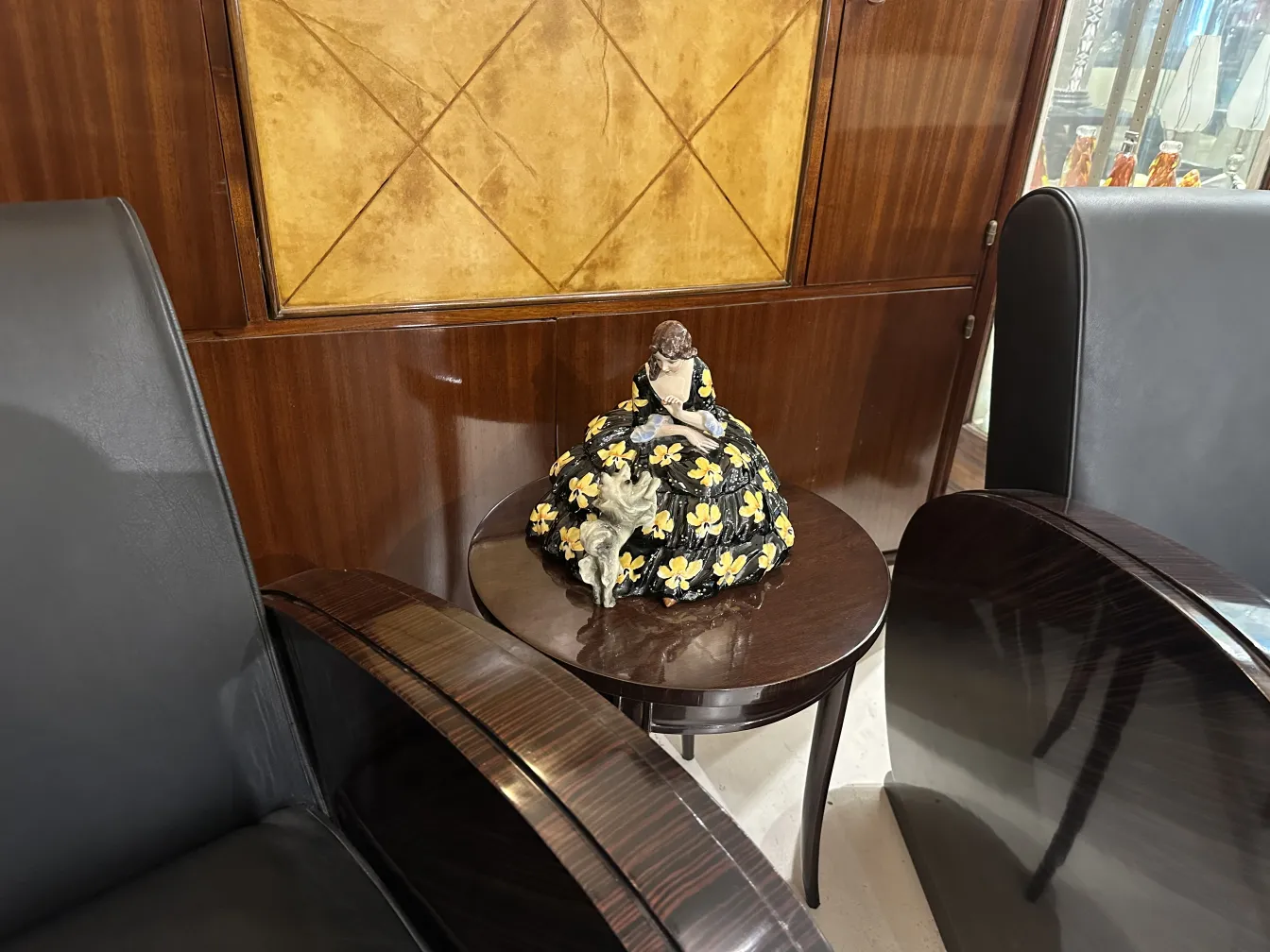 Figura decorativa de cerâmica antiga com flores amarelas em fundo de madeira
