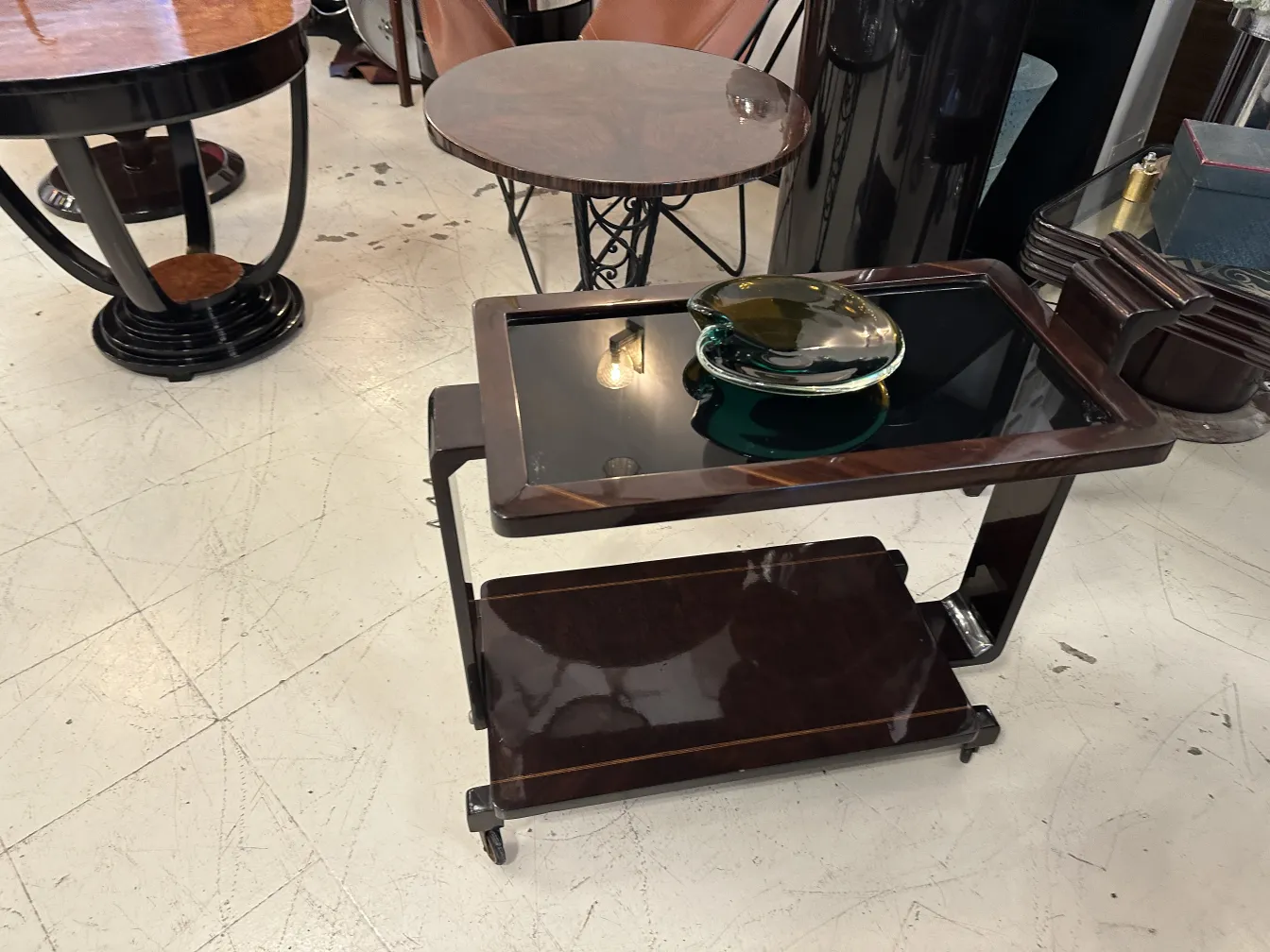 Ancien cristal de Murano sur un chariot en bois, avec un fond élégant et des détails décoratifs.