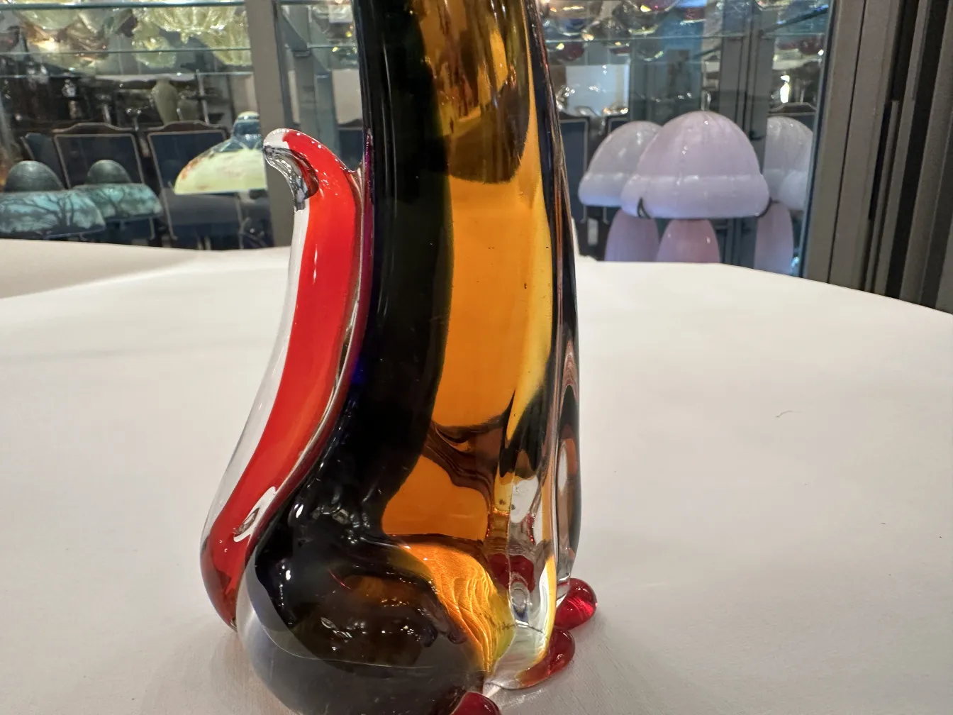 antique murano sculpture with red, black, and orange colors in an elegant setting