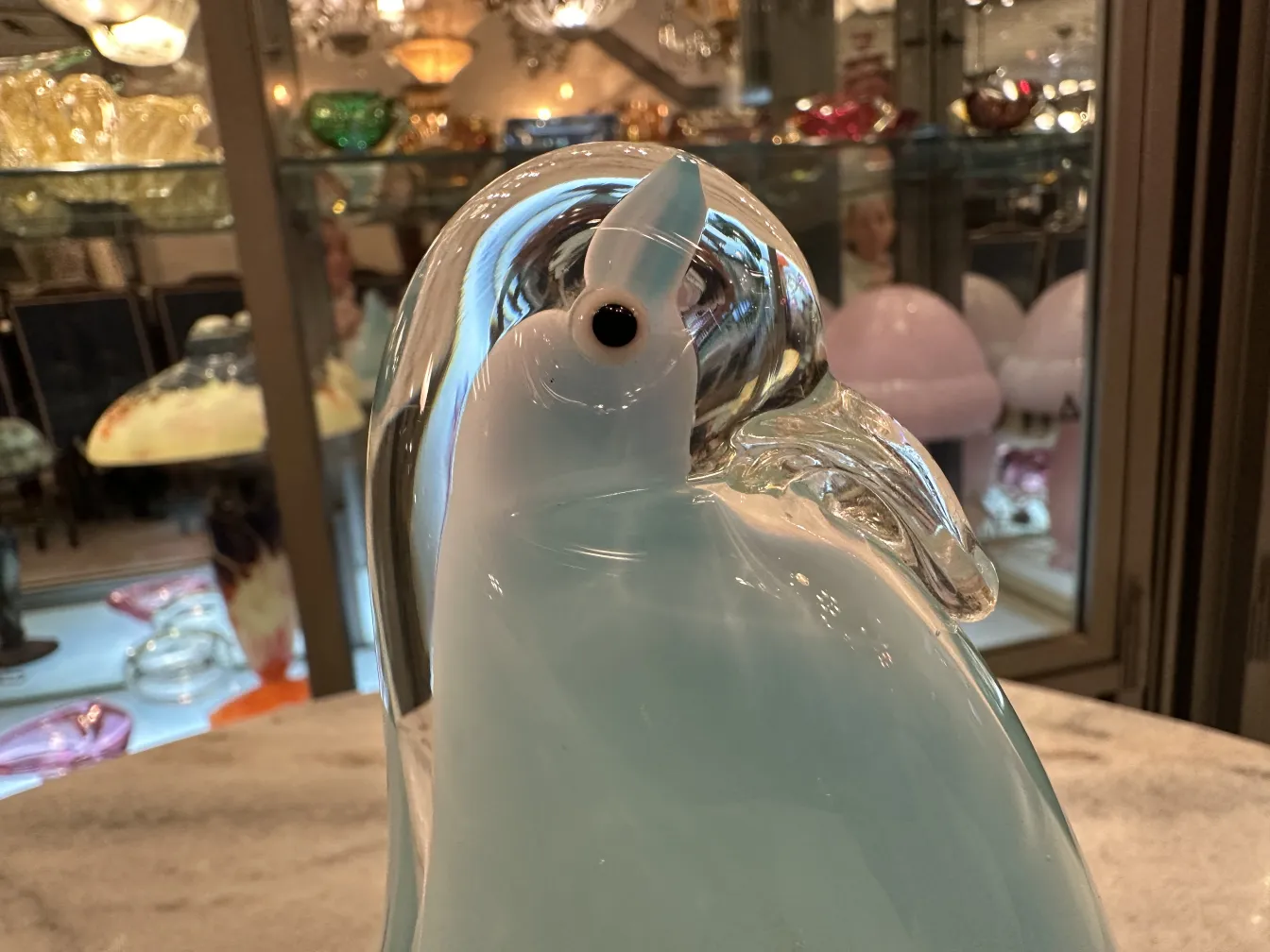 escultura antigua de murano en forma de pingüino, colores suaves