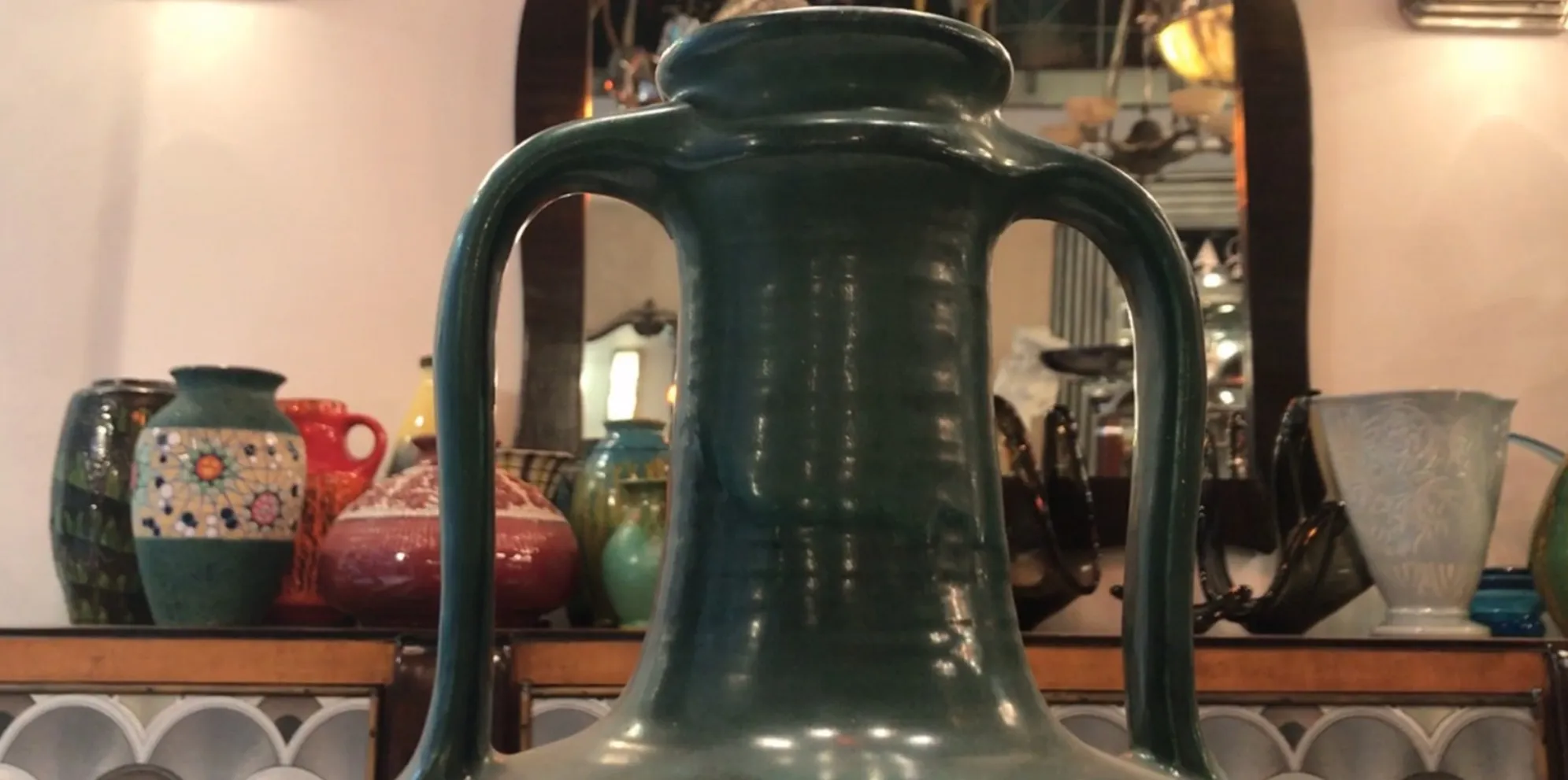 Jarra antigua de cerámica decorativa en fuerte color verde con asas