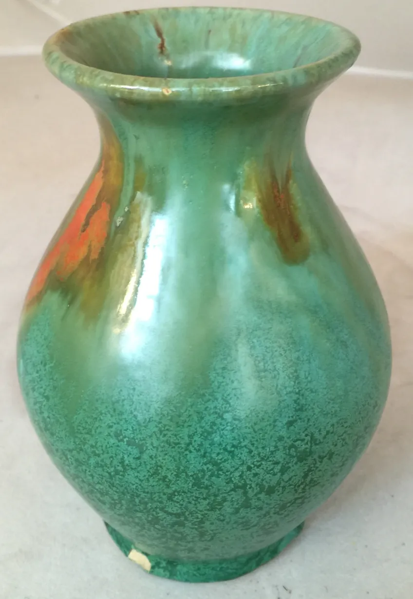 Vaso antico in ceramica con tonalità verdi e arancioni e dettagli decorativi unici