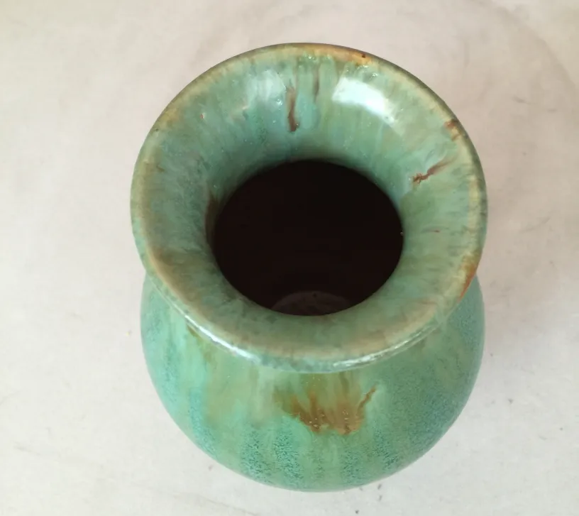 Vaso antico in ceramica con tonalità verdi e arancioni e dettagli decorativi unici