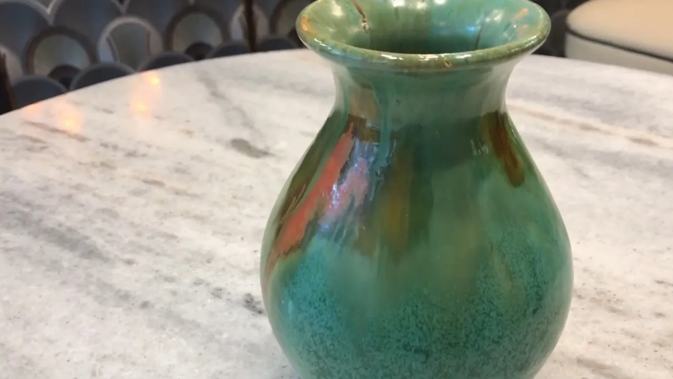 Vaso antiguo de cerámica en tonos verdes y anaranjados con detalles decorativos únicos