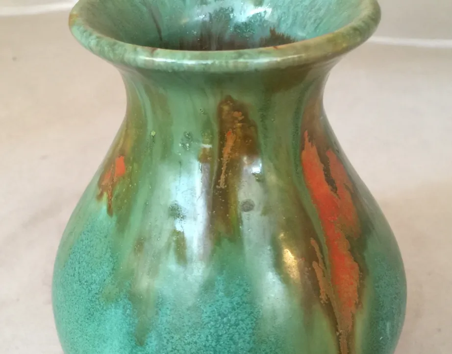 Vaso antigo de cerâmica em tons de verde e laranja com detalhes decorativos únicos