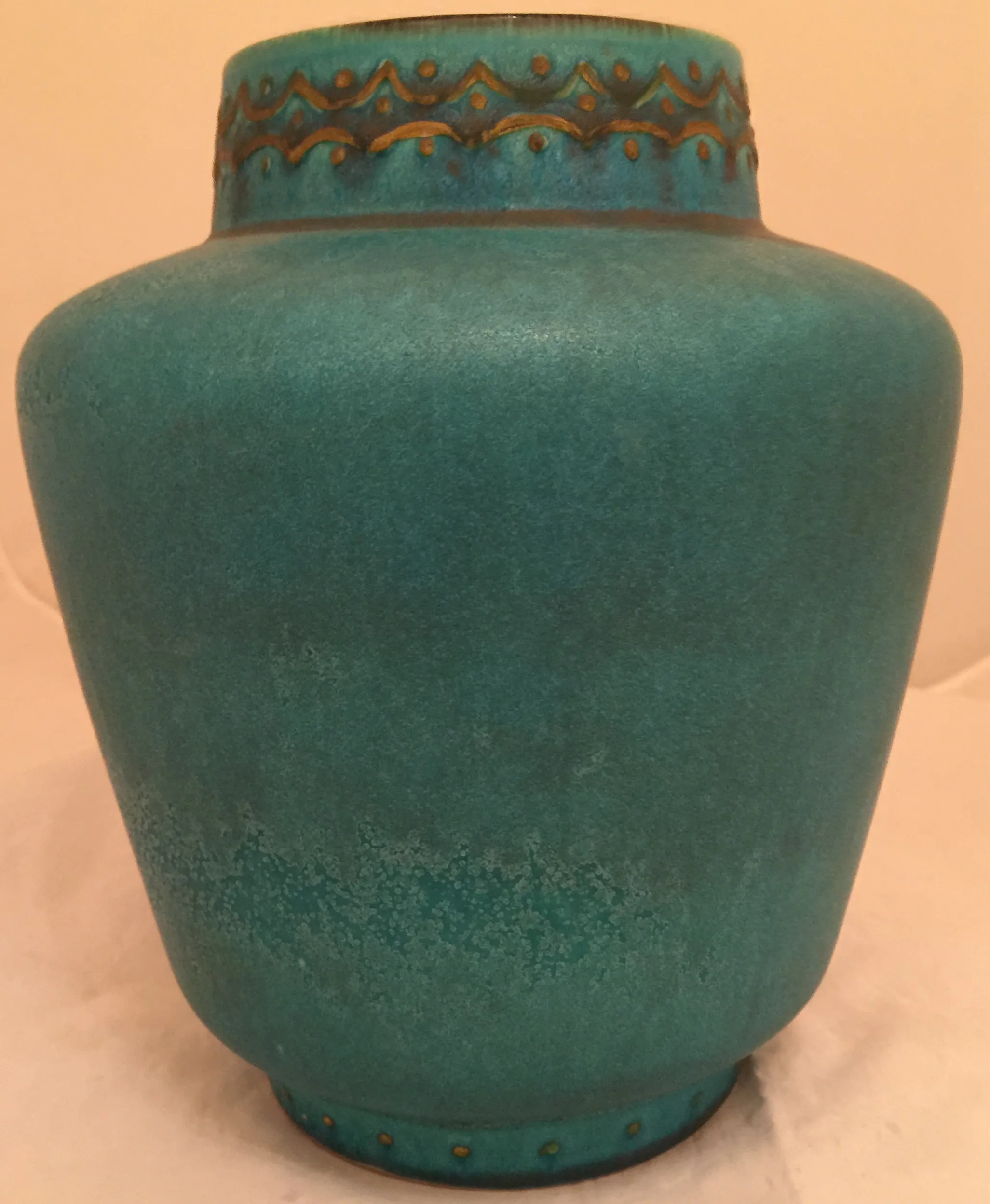Jarros antigos de cerâmica na cor turquesa, com detalhes decorativos na parte superior, em fundo claro.