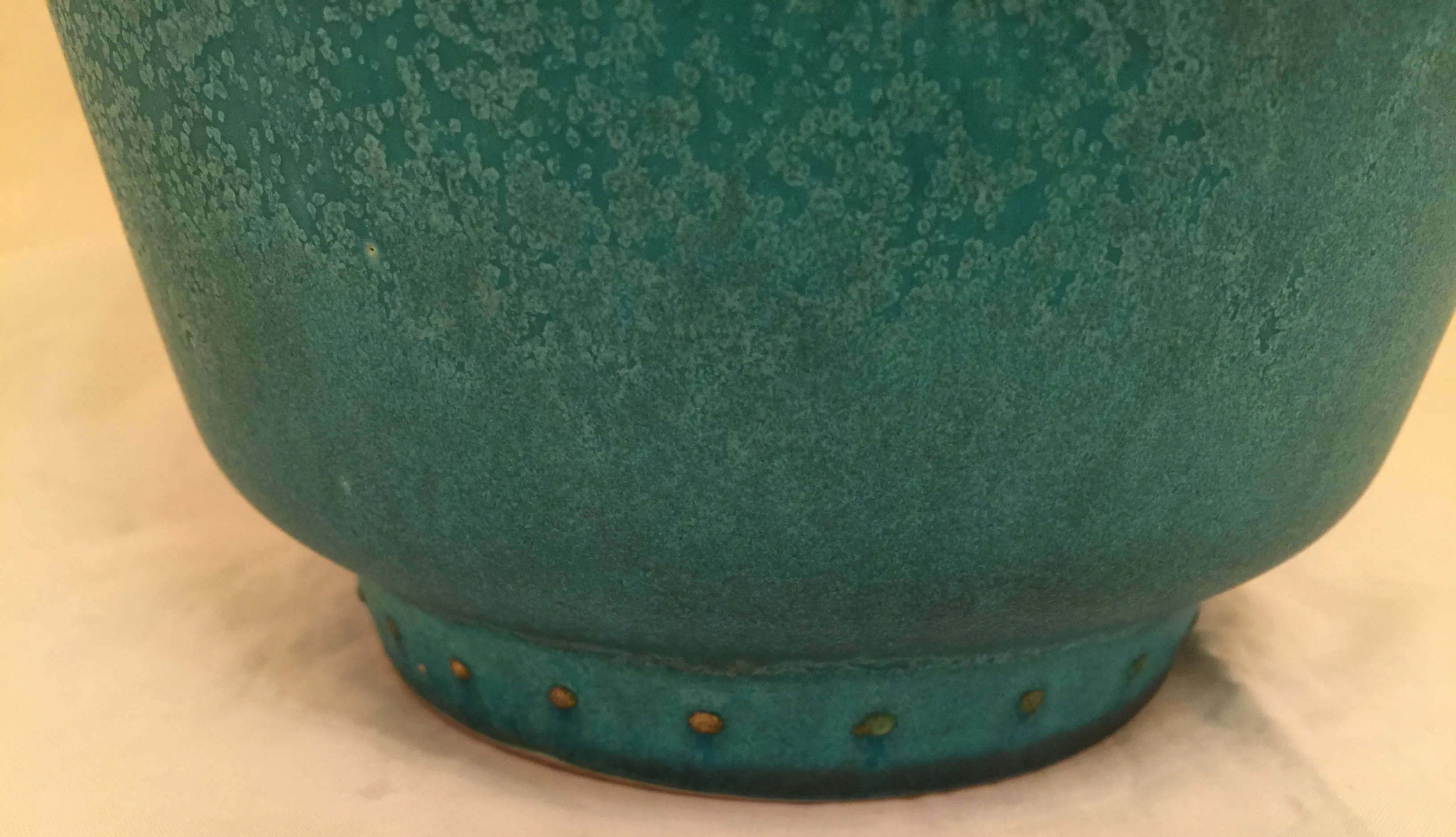 Ceramica antica in toni verdi con dettagli colorati