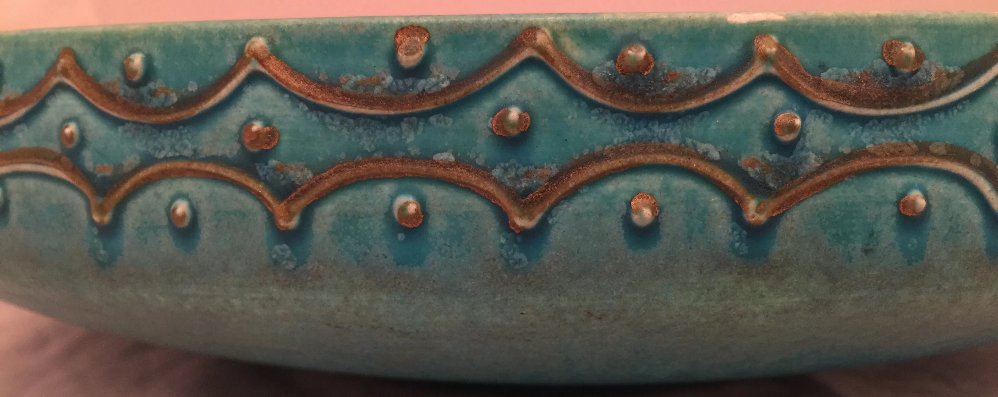 Antigua cerámica decorativa azul con detalles dorados.