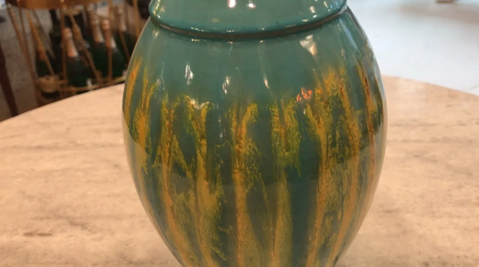 Antigua cerámica con diseño azul y verde en forma de jarra