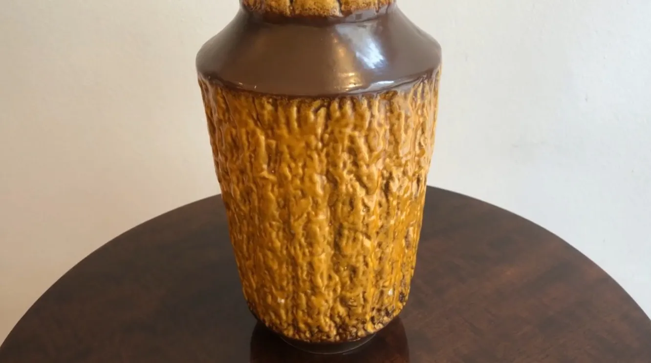 Vaso antico in ceramica color ambra con texture ruvida.