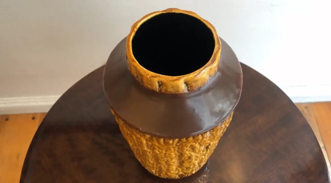 Vaso antico in ceramica con design texturizzati in giallo e marrone.