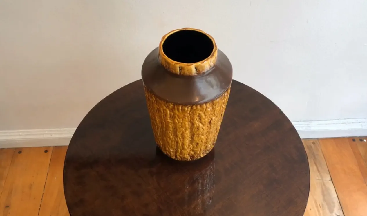 Vase antique en céramique de couleur ambre avec une texture rugueuse.