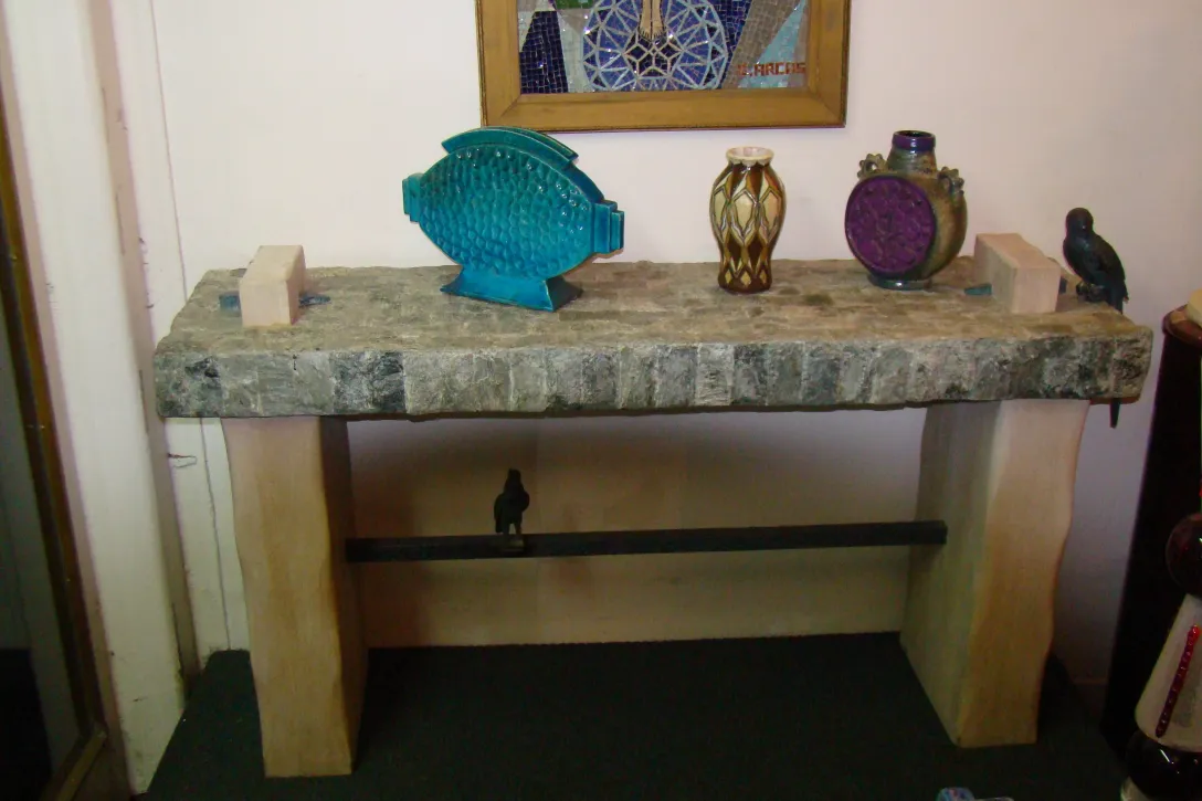 Una mesa con antigüedades decorativas de cerámica en la parte superior.