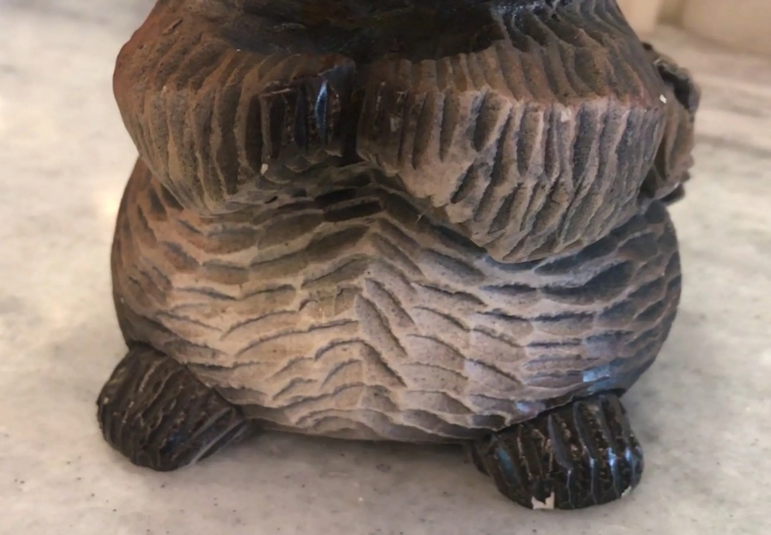 Figura de cerámica antigua con detalles rugosos y patas