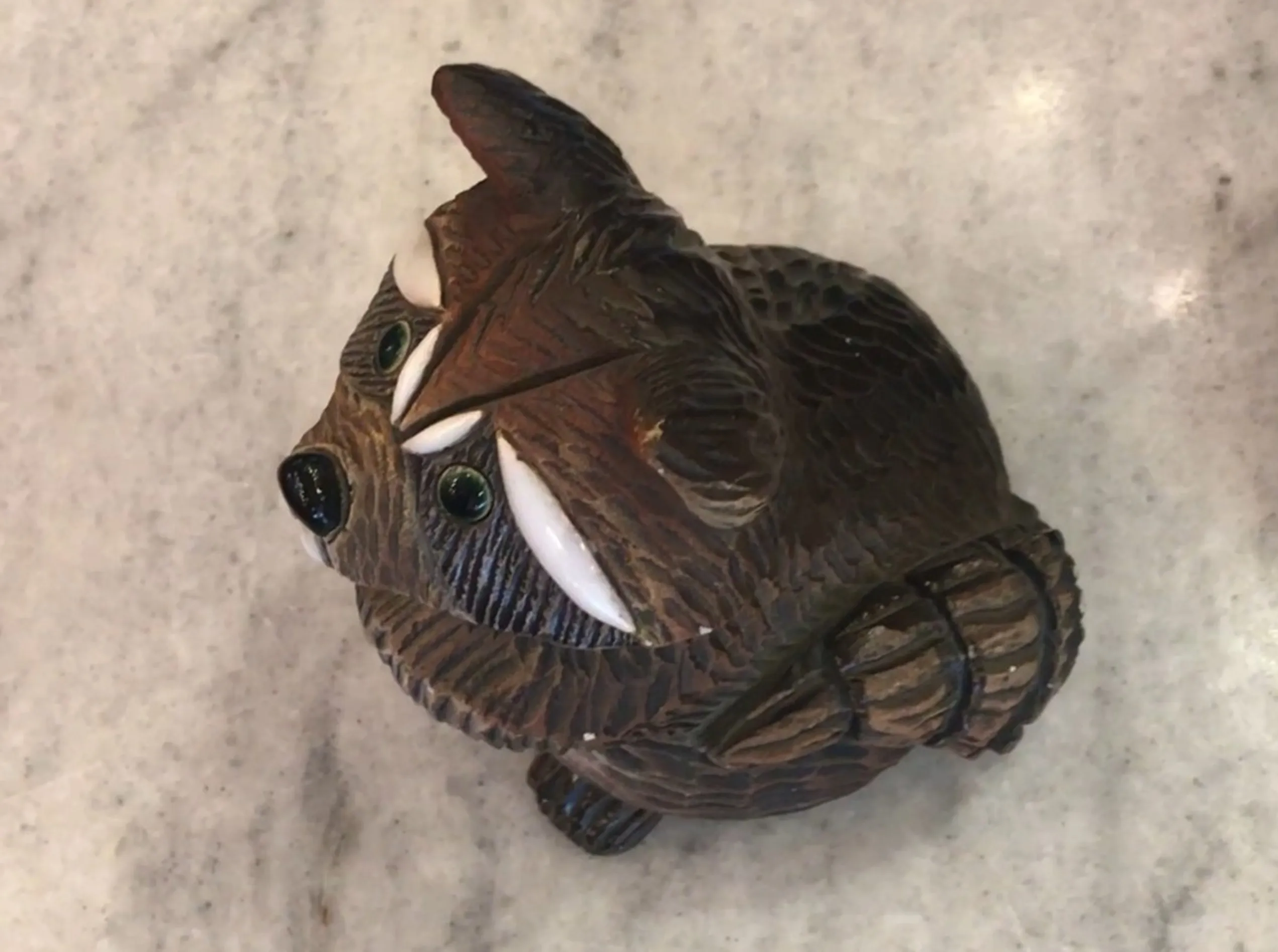 Figurita de cerámica antigua con forma de animal, detalle en el entorno.