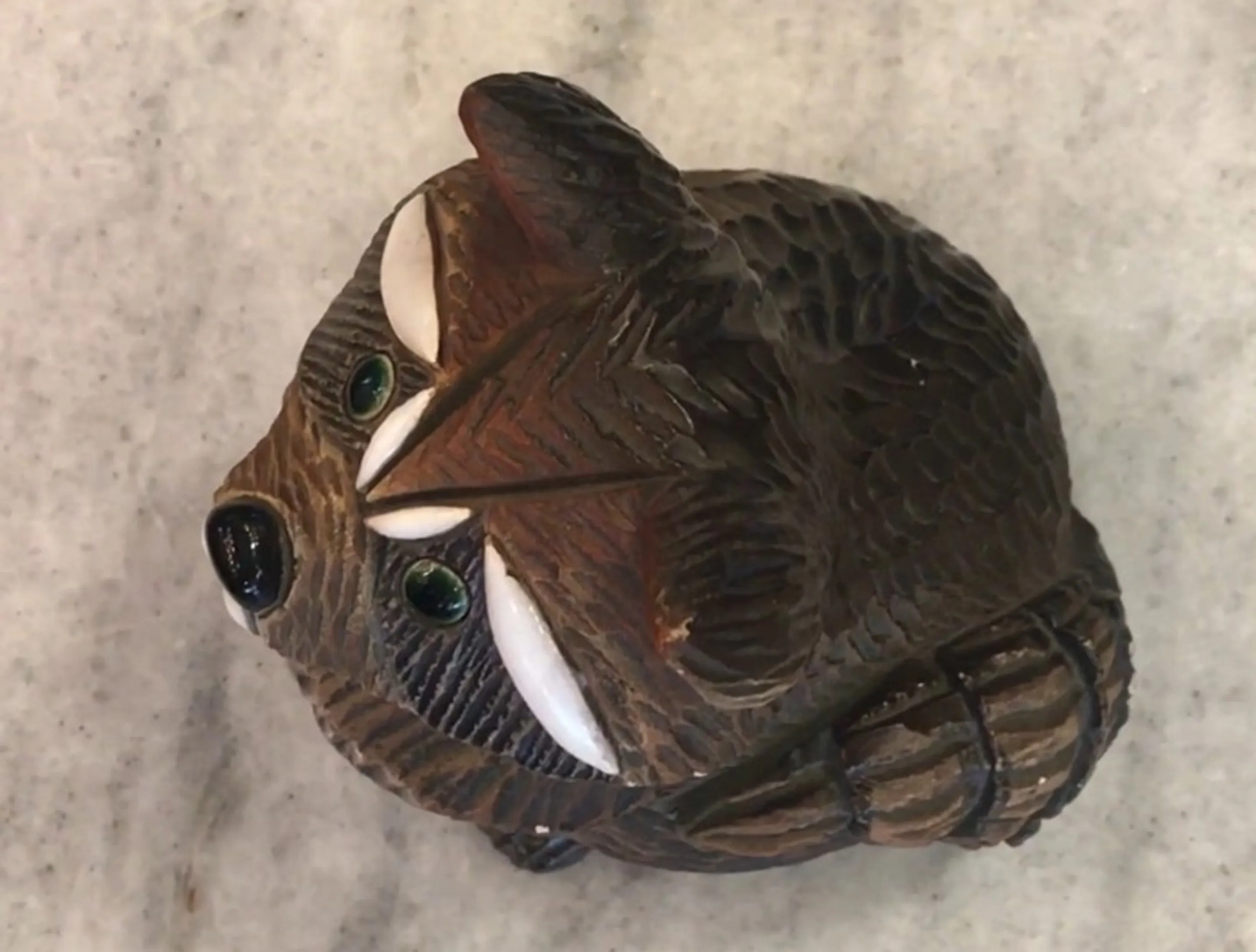 Antike Keramikfigur mit braunen Details und grünen Augen, Stil der artesania Rinconada.