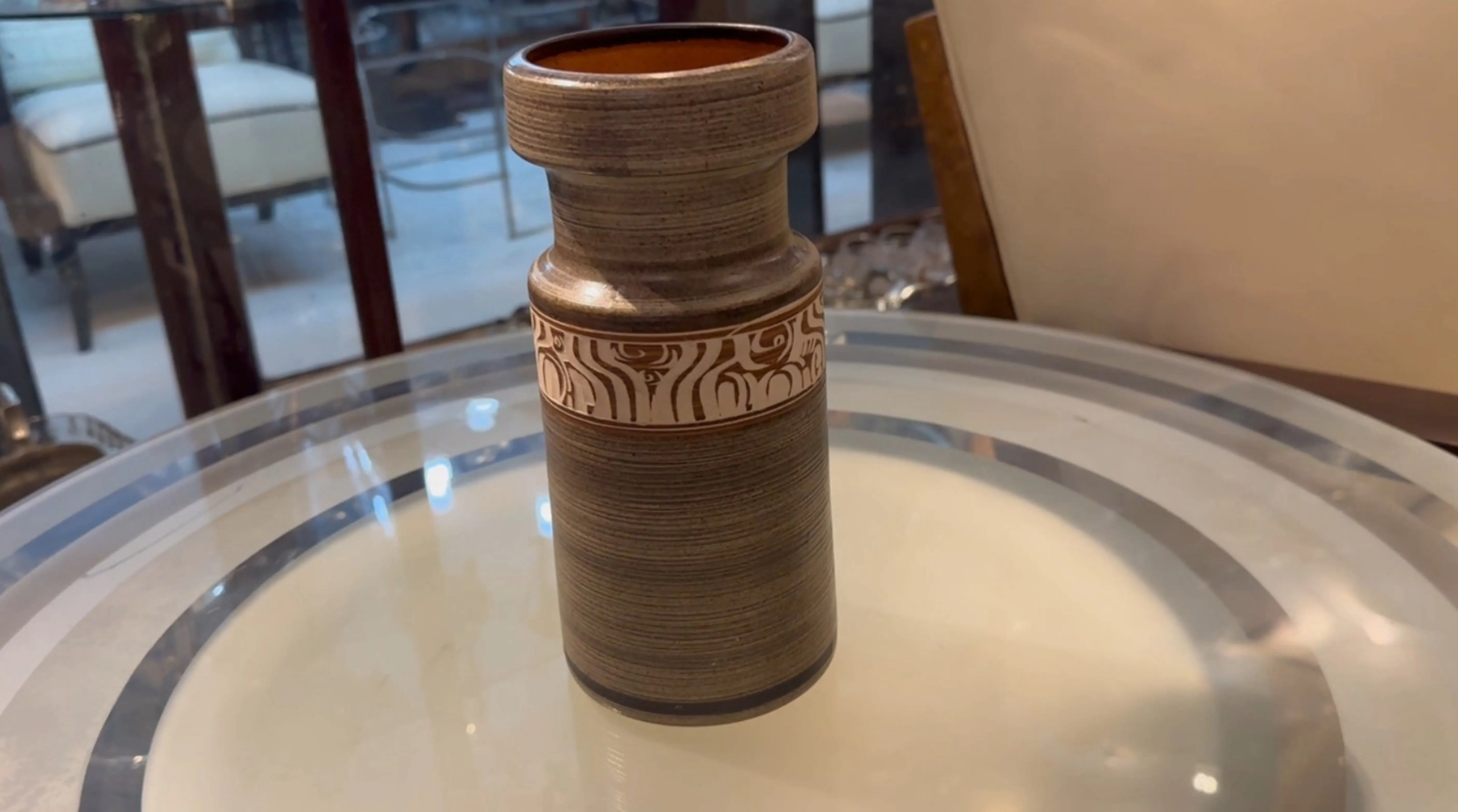 Pièce de céramique ancienne décorative avec des motifs uniques et une forme stylisée.