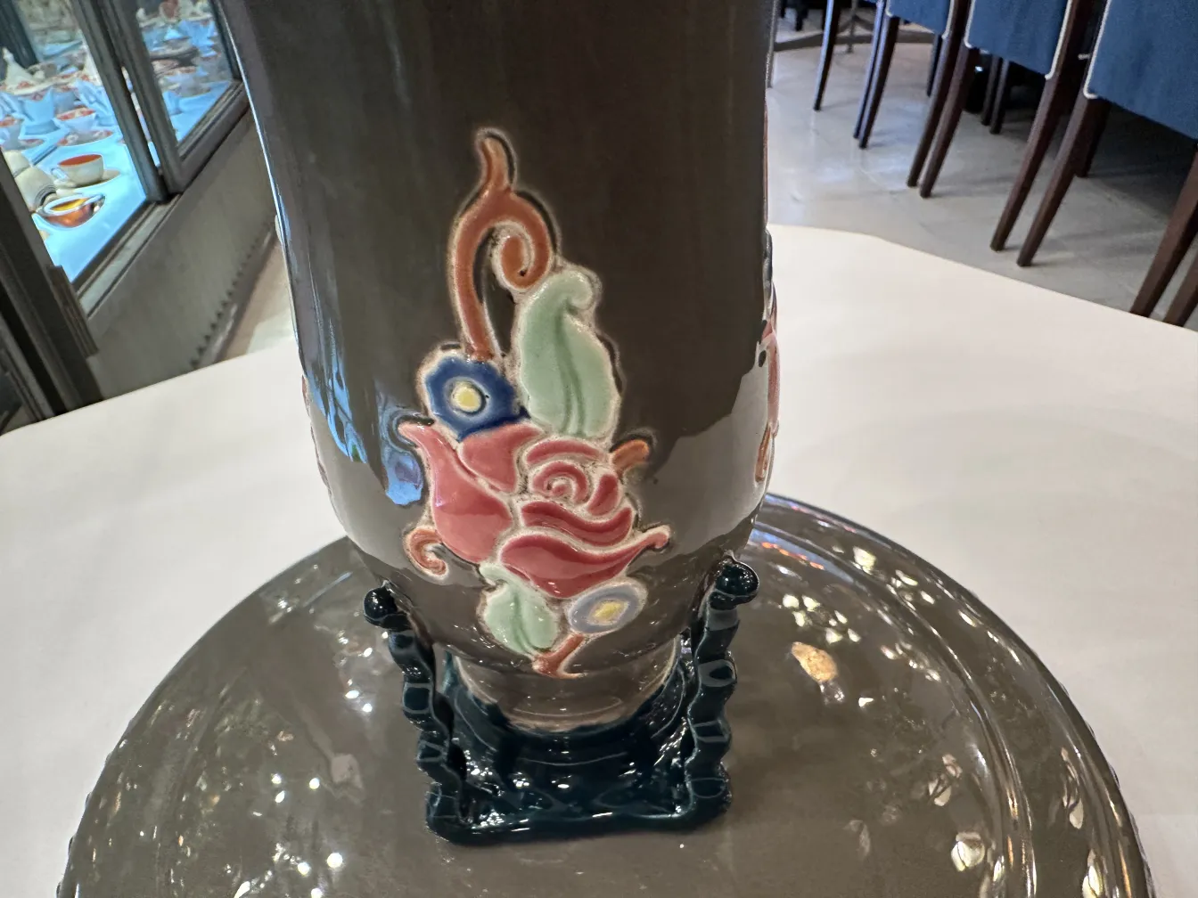 Antique ceramic vase with vibrant floral designs.