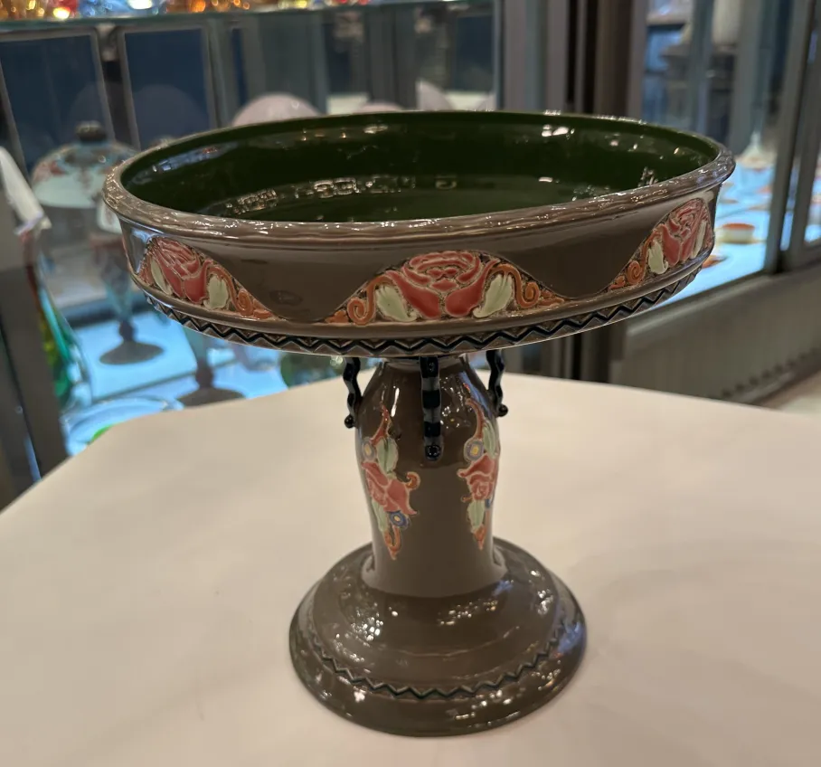Antigua cerámica Eichwald con decoración floral en verde y marrón, base elegante.